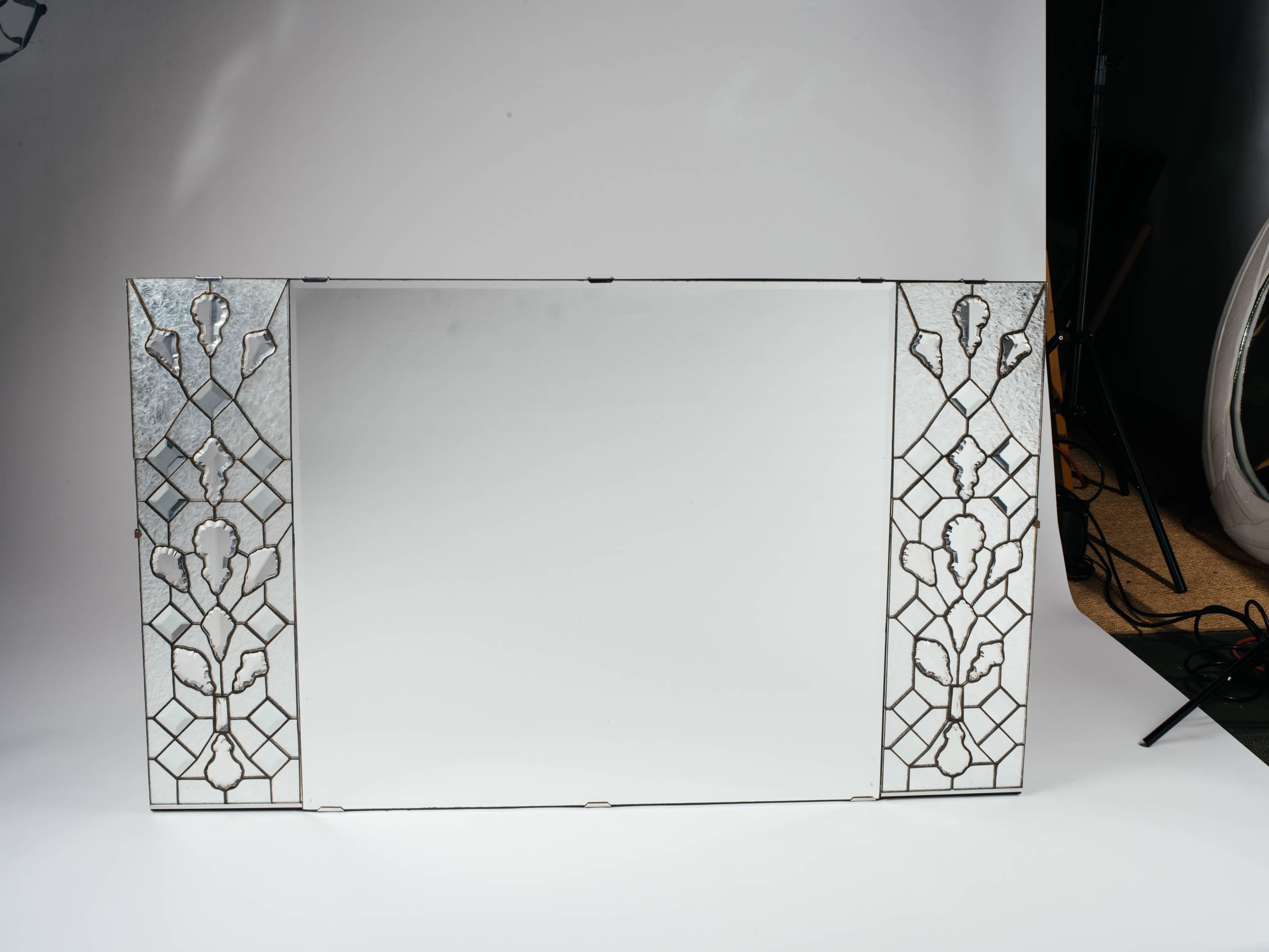 Exquisite and opulent Mid-Century Modern rectangular mirror with Hollywood Regency design. Features transparent stained glass panels on either side, and fitted with stunning large cut crystals.