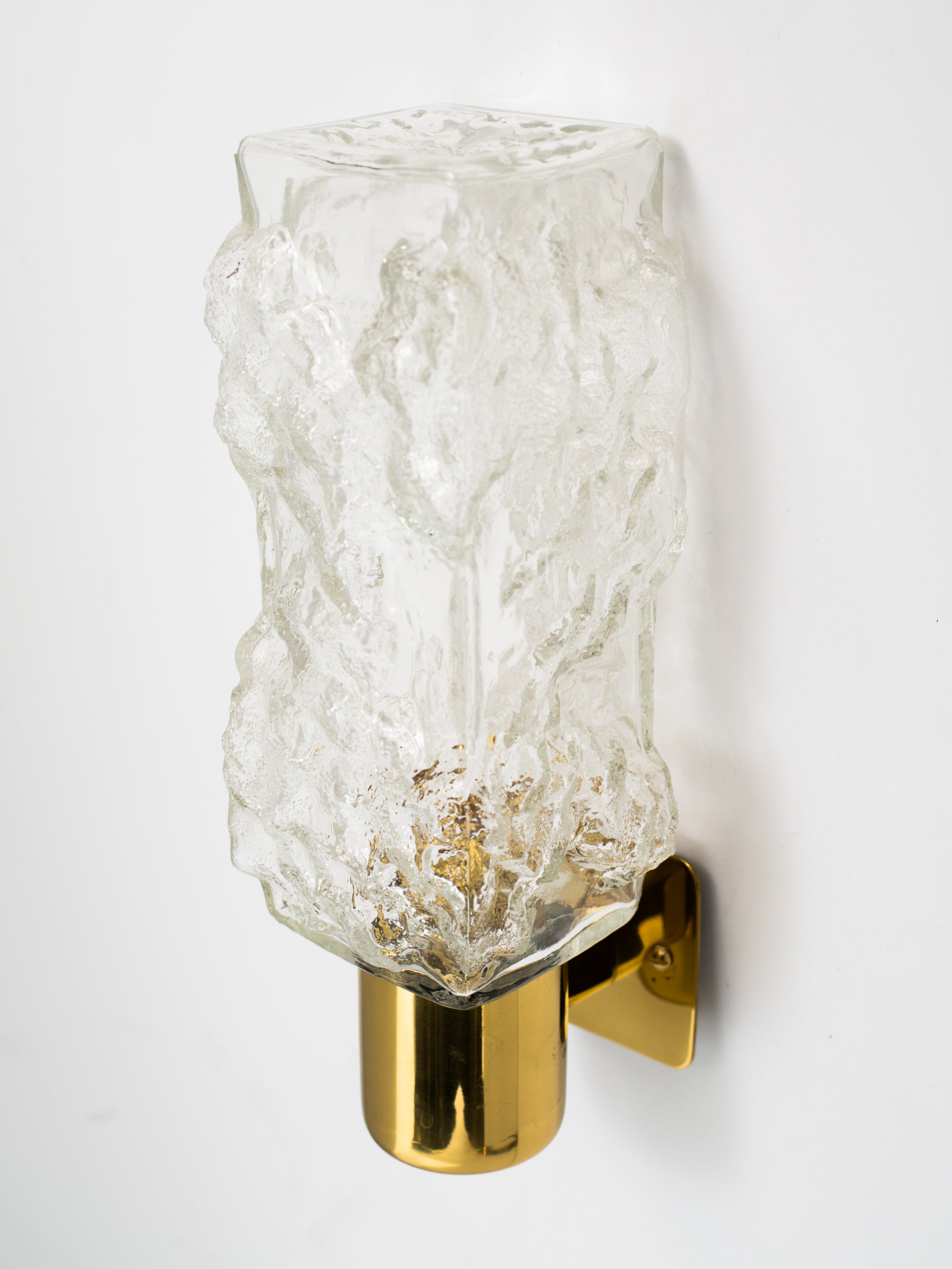 Mid-Century Modern sconce with Brutalist design.  Murano glass shade has an elongated cube design with ice texture and is fitted with a petite polished brass frame.
