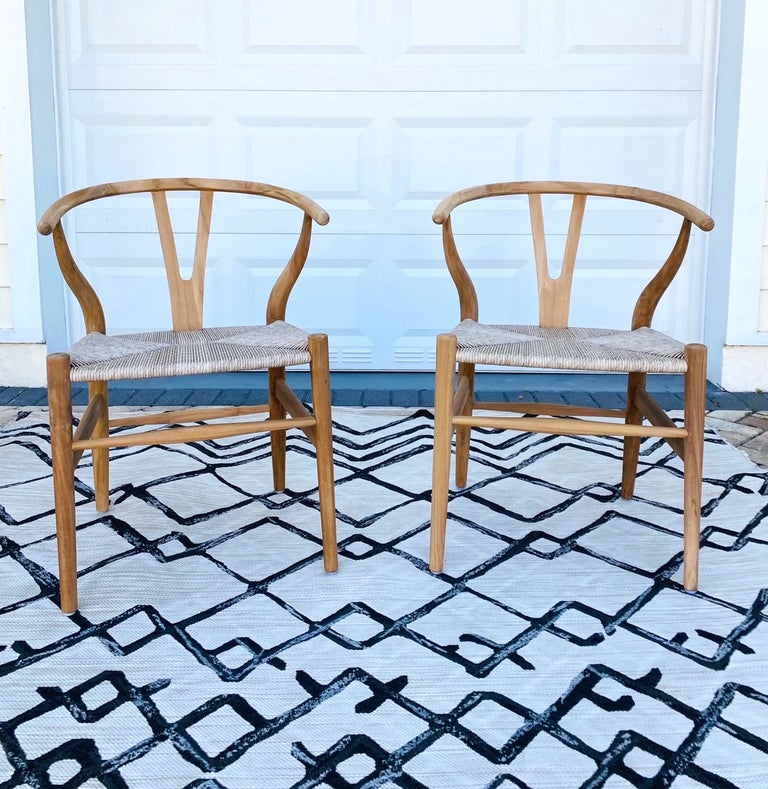 Mid-Century Modern chairs in solid teak wood with a natural finish. Handcrafted curved frames feature a rounded top with Y-back design. The handwoven cord seats add to its organic beauty. Classic and timeless design makes these great accent chairs