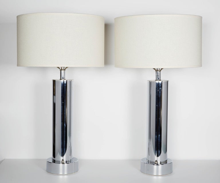 Pair of outstanding Art Deco table lamps with Minimalist design. The lamps are comprised of simple and elegant cylinder forms with raised circular bases in polished chrome. Each lamp also has a chrome ball finial fitting along the base. Recently