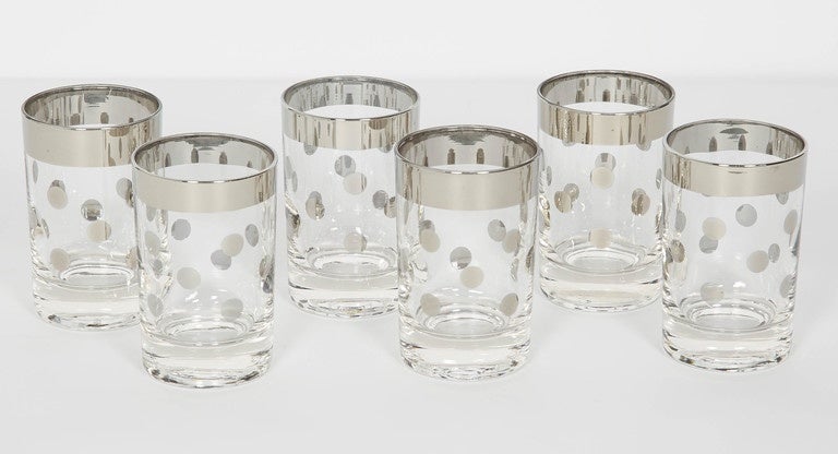 Mid-Century Modern barware glasses consisting of six perfect cylinder cordial glasses. The glasses have a chic silvered metal trim with polka dot design. Makes a smart and cheerful addition to any barware set or serving set.