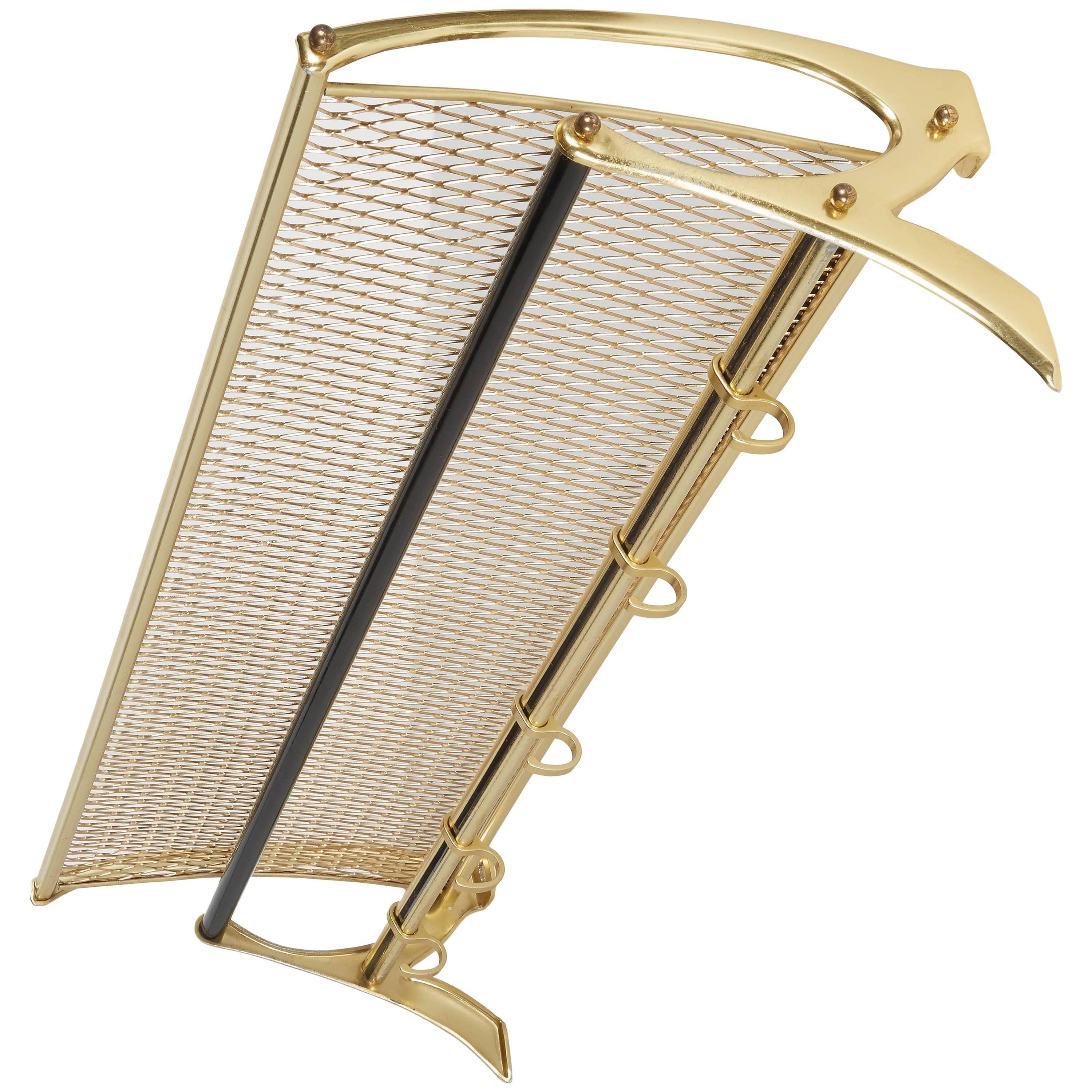 Austrian Mid-Century modern coat and hat rack with wall mount design.
Brass-plated metal with modernist design includes gold metal grid top shelf and cross bars with black enameled details. Fitted with five sliding coat or jacket hooks. Great