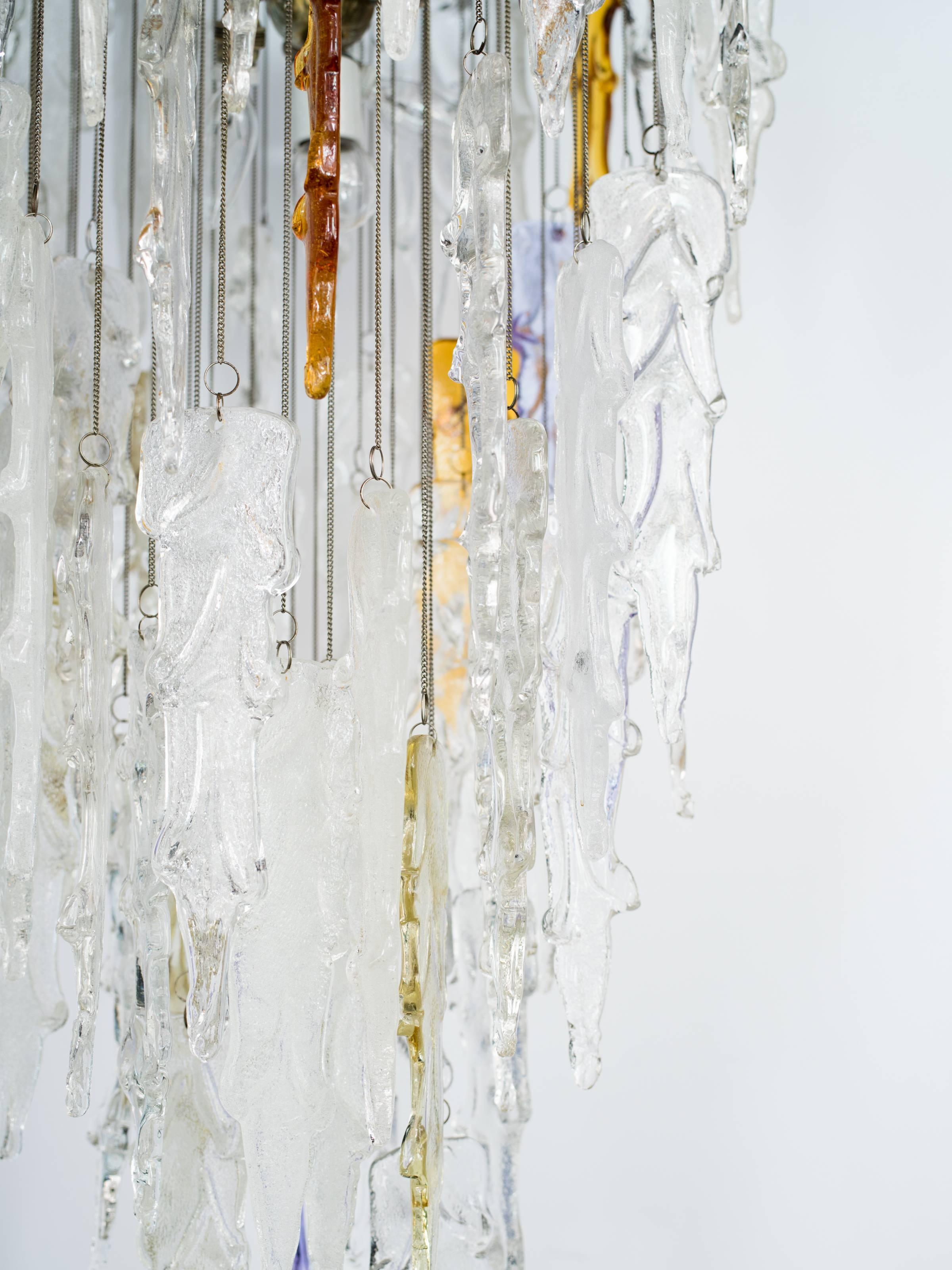 Magnificent and rare chandelier comprised of handblown Murano glass pendants with organic icicle formations. Pendants hang at varying heights from individual chain fittings, creating a multiple tier design. Chandelier features amorphous clear and
