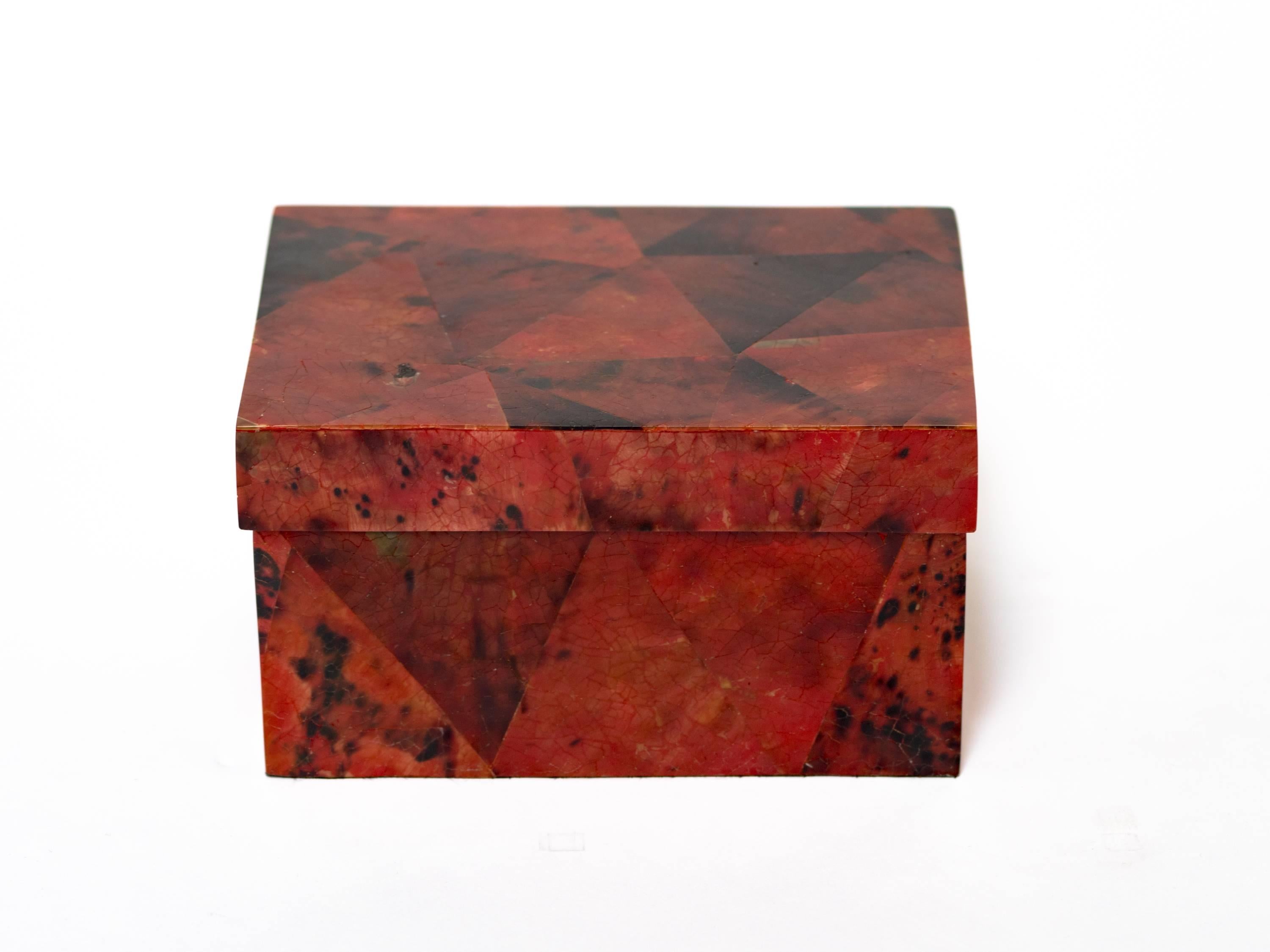 Gorgeous handcrafted box comprised of lacquered pen shell. Hand-dyed in variant hues of ruby red and black. The box has a graphic mosaic geometric design. The lid opens to reveal a palmwood interior. Makes a great jewelry box or desk accessory.