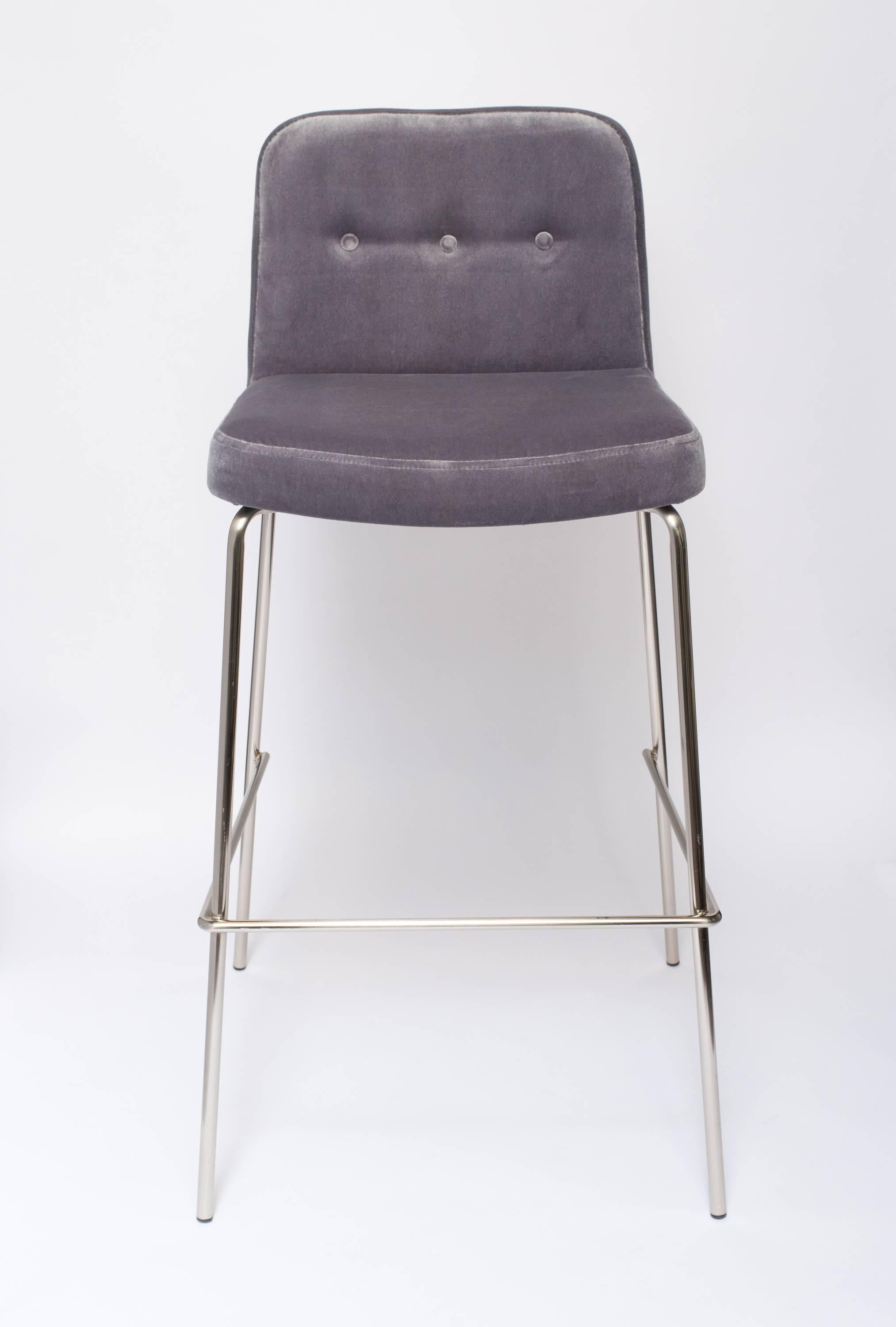 Tall bar stools with low back design. Great mid-century modern design featuring chromed steel frames. Newly upholstered in luxe grey velvet. Stools have button back details with footrest frames.