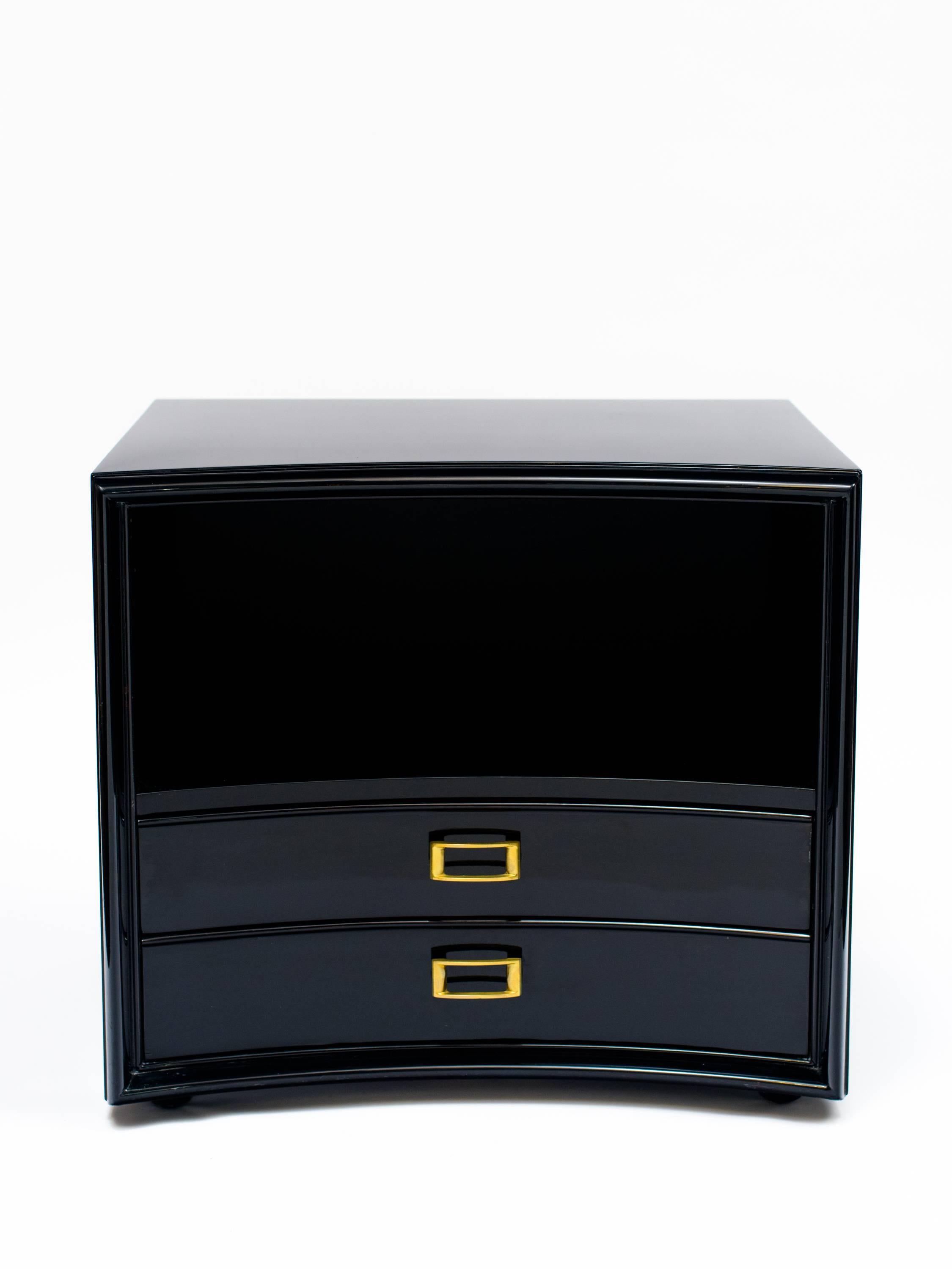 Gorgeous mid-century modern end table or nightstand with bowed front. Has open shelving and display area and is fitted with two lower drawers. Ebonized walnut wood with brass hardware. Designed by Paul Frankl for Johnson Furniture.