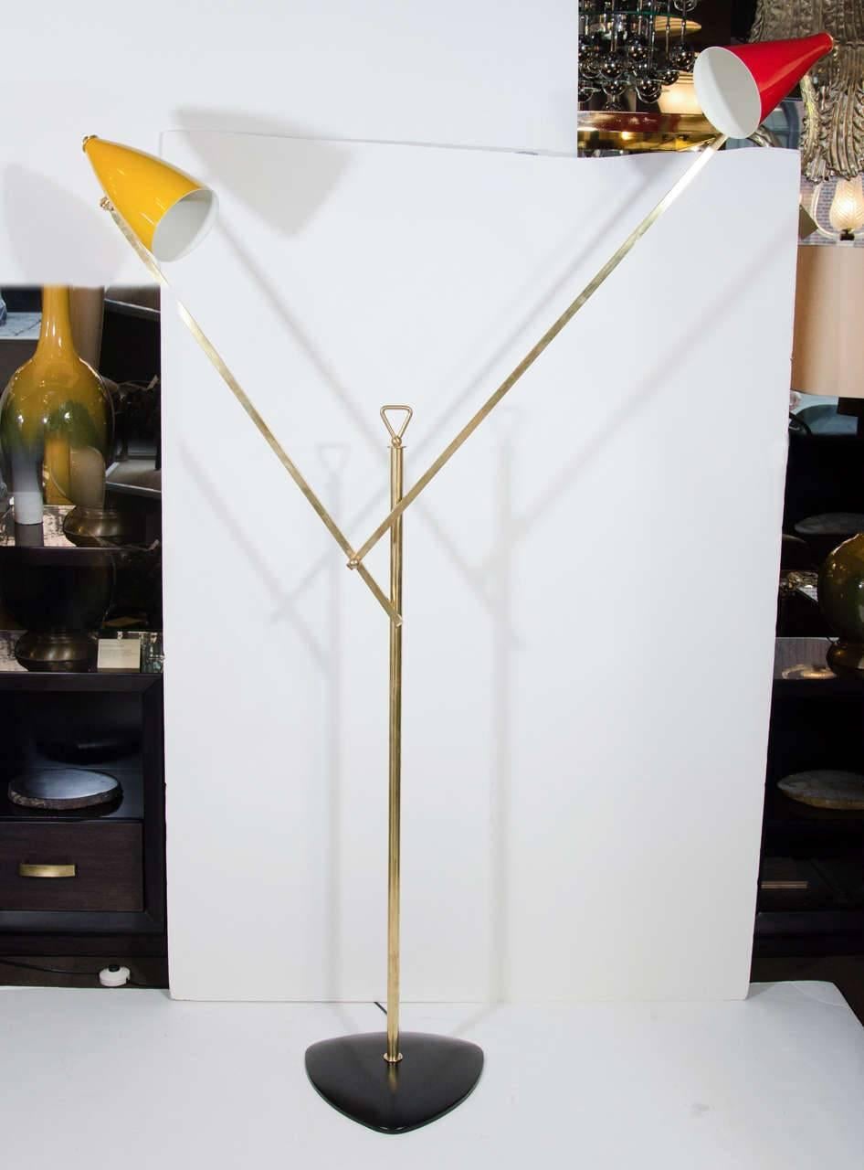 Rare mid-century modern Italian architectural floor lamp. Features asymmetrical frame with geometric arm design in a brass. Has adjustable lamp shades in vibrant primary red and yellow. The shades have enameled finishes in different, yet