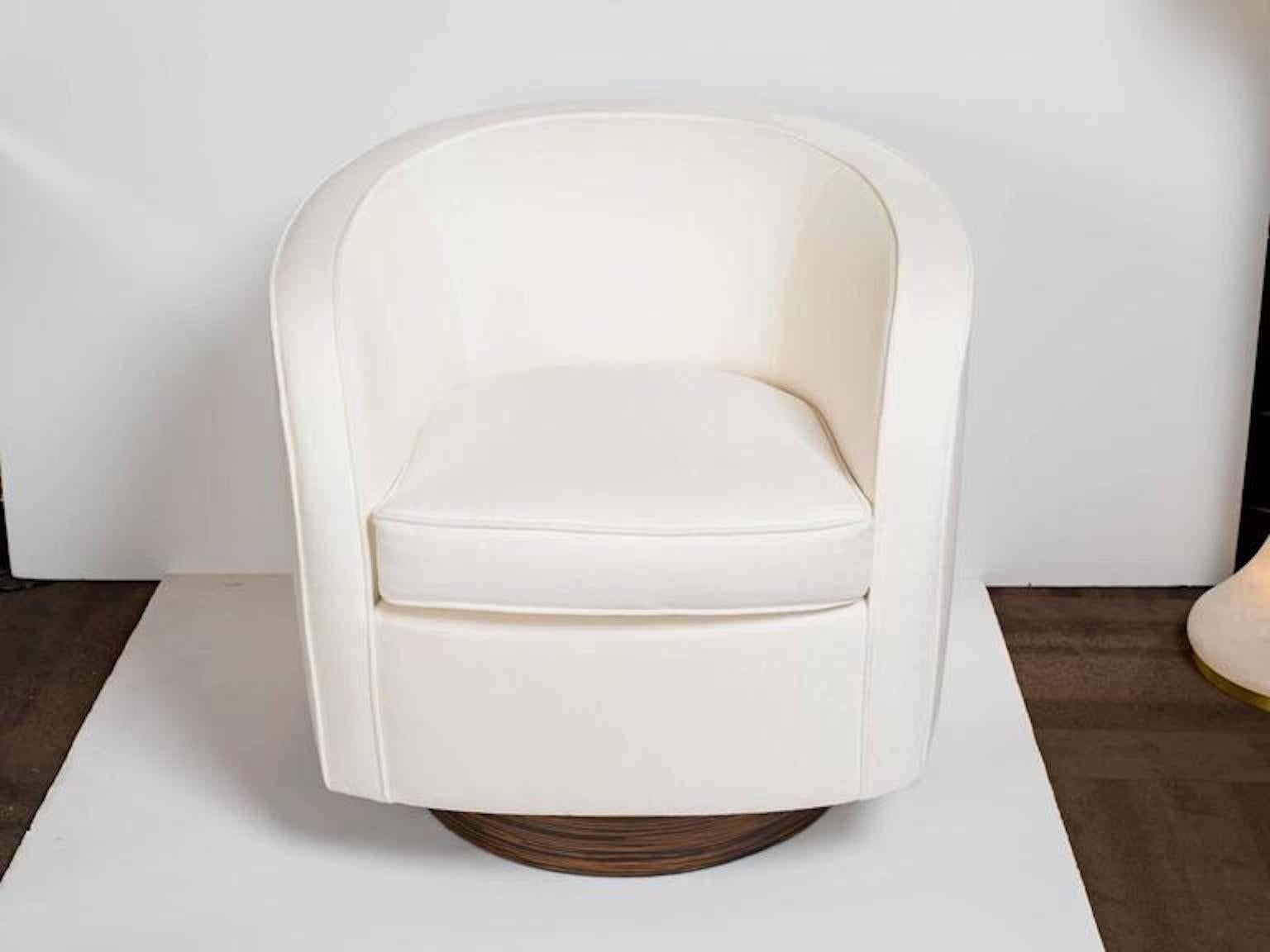 Mid-century modern chair with streamline barrel back design. Newly upholstered in a luxurious ivory velvet fabric with self welt details. Functional 360 degree swivel base in striking zebra wood.