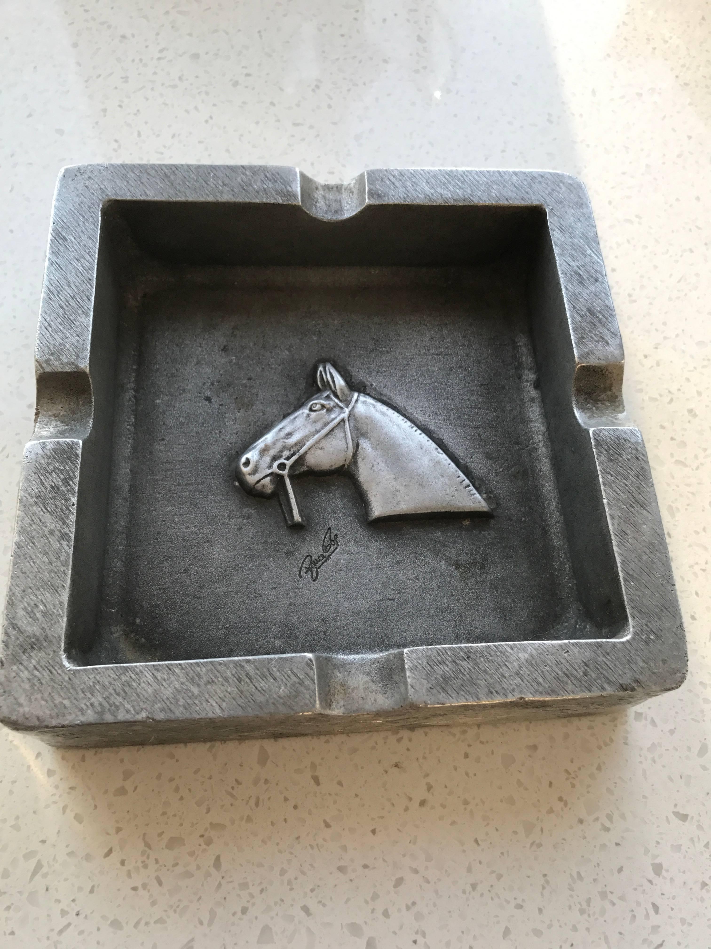 Mid-Century pewter ashtray with horse and bit theme. Hand-forged design in heavy weight cast pewter, with incised graphic lines along the borders, and fitted notches for cigarettes or cigars.