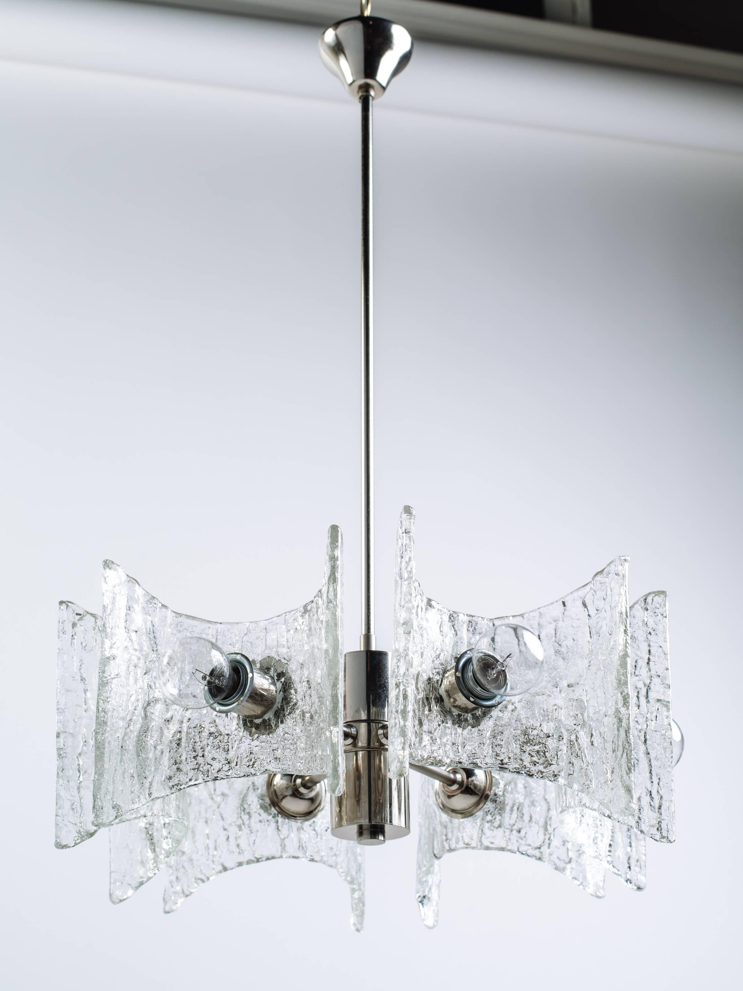 Modernist chrome chandelier with brilliant textured glass design. The chandelier is fitted with six lights and six handblown shades with curved design and stylized pointed corners.
