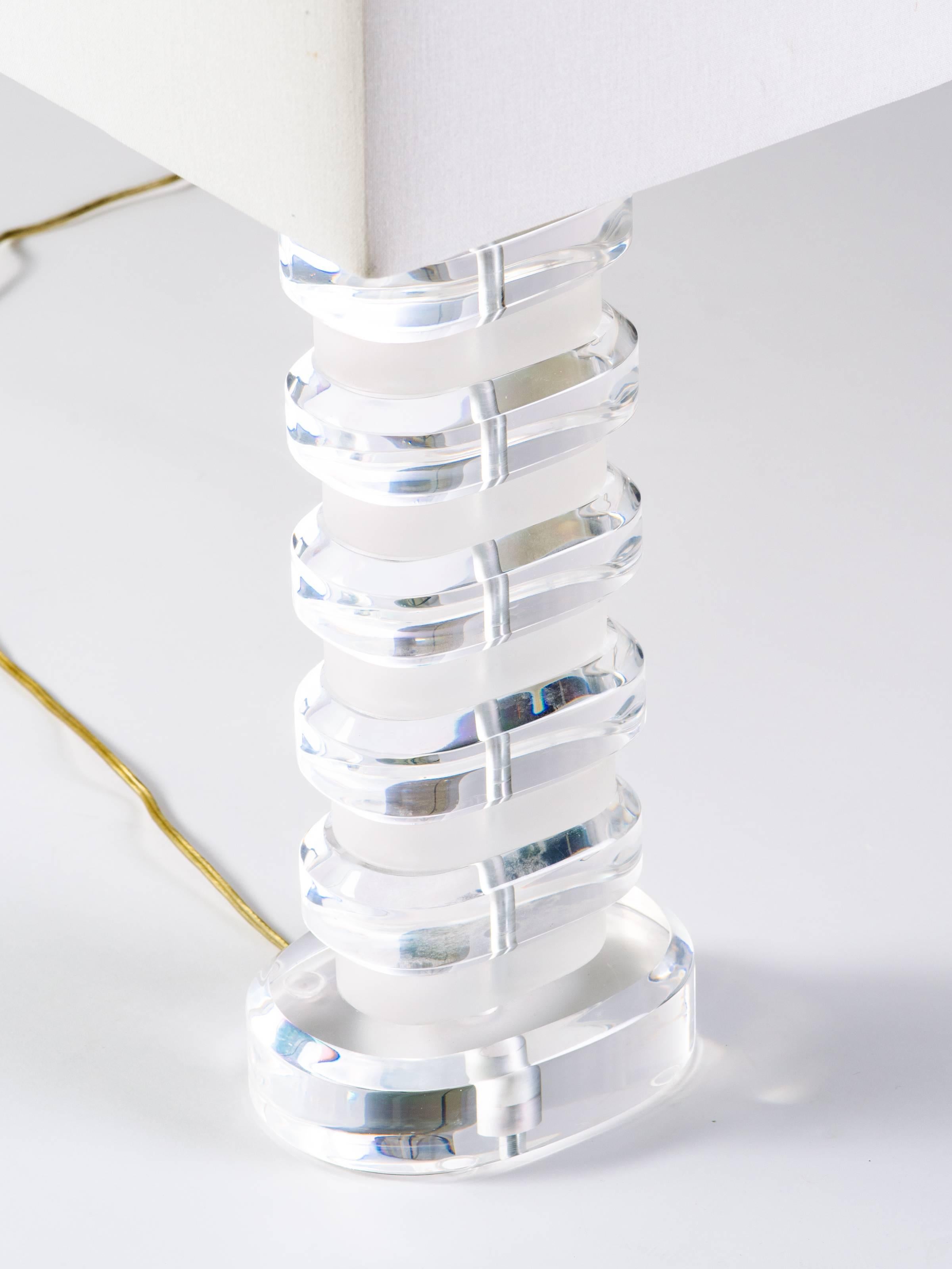 Very chunky Lucite lamp. Features stacked solid Lucite blocks, both clear and frosted with polished edges and oval forms. Has original diamond shaped Lucite finial.