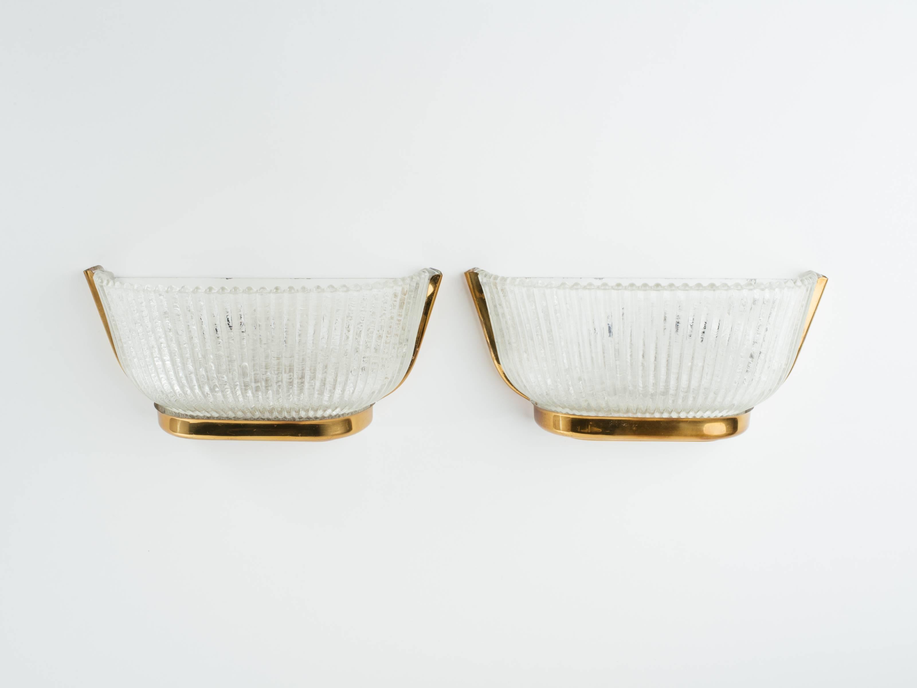 Elegant fluted bubble glass sconces with patinated brass frames and neoclassical urn form. Fitted with two lights each.