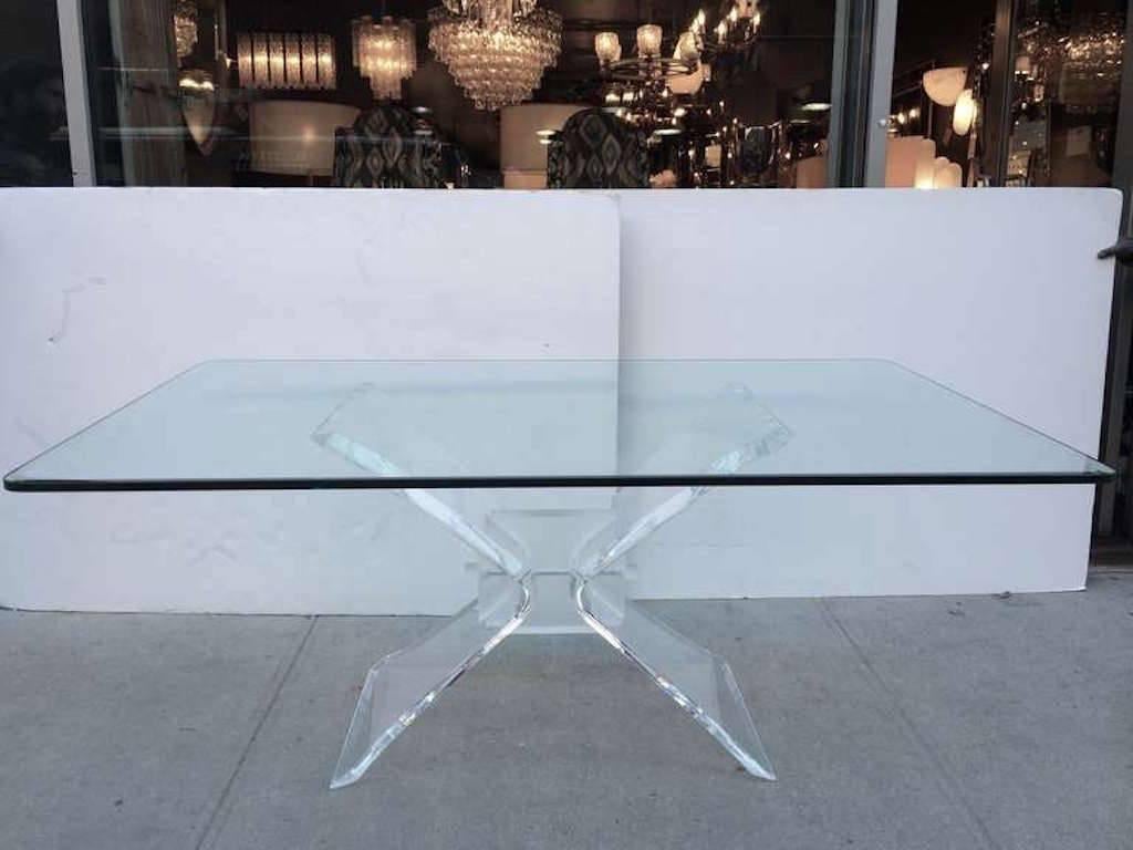 Mid-Century Modern dining table with hand beveled glass top and architectural butterfly base design. Base is comprised of thick sculptural Lucite with frosted Lucite block centre and rivets.