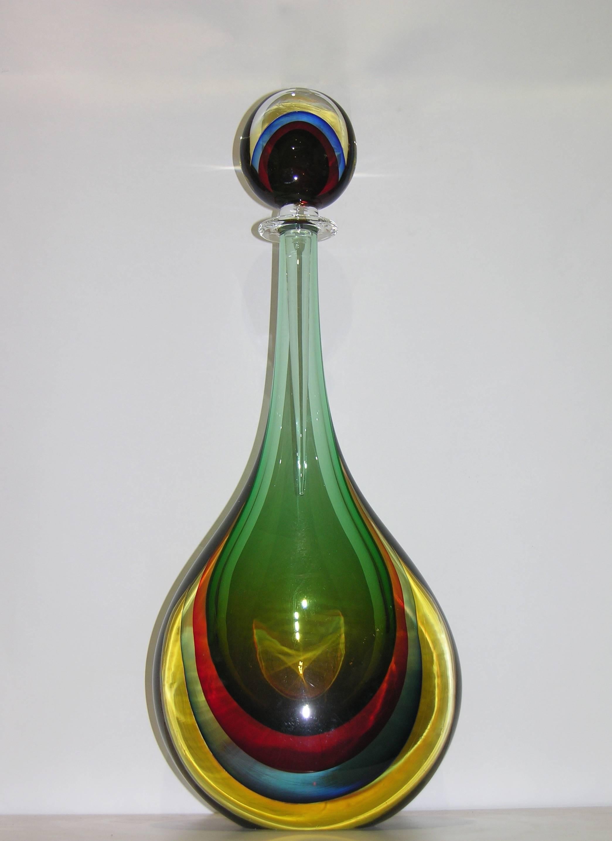 A rare pair of large sized bottles with drop stoppers in Murano glass by Formia, beautiful and sophisticated decoration with the Sommerso technique, the green body encased in the lower part with three colored layers, red, blue and yellow. The fact