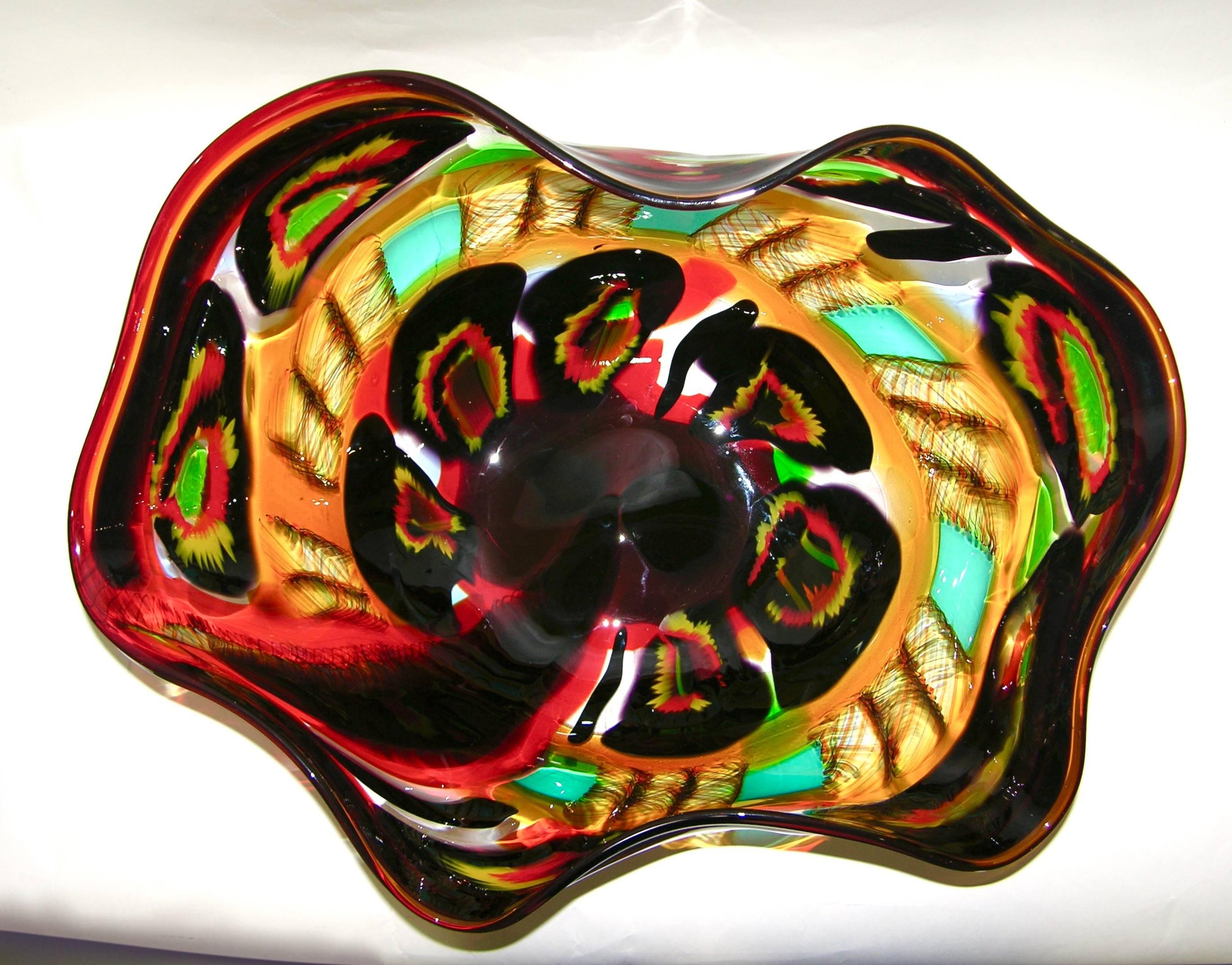 Italian one of a kind Work of Art in blown Murano glass, signed by Afro Celotto and dated 2001, 1/1, a statement on a dining table. A majestic free-form centerpiece, worked with a black and red border decorated with multicolored Murrine in yellow,