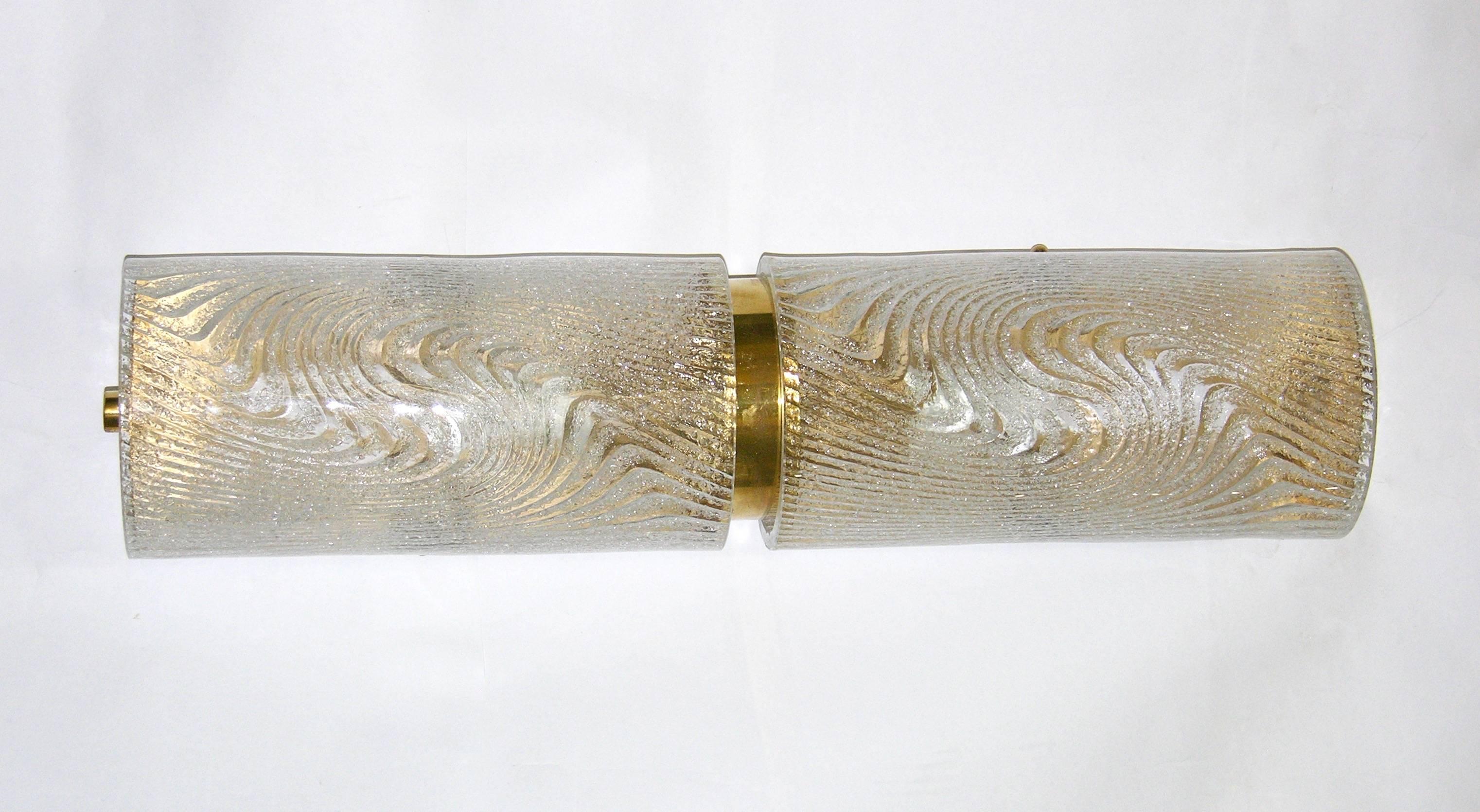 A very elegant pair of lights mounted on a handmade brass structure with curved Murano glasses sophisticatedly decorated on reserve with an attractive swirling frosted pattern. This technique, allowing the brass to show through the decor, confers a