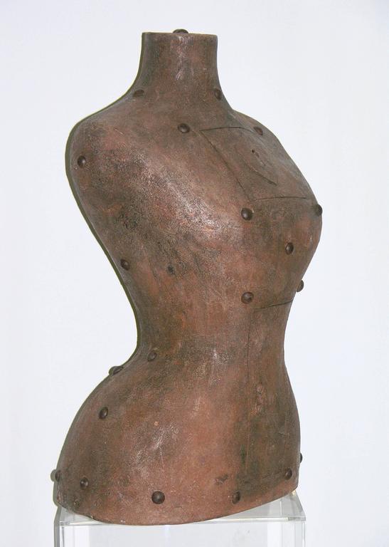An exclusive organic contemporary work of Art by the Italian artist Ginestroni. A couture bust in terra cotta exceptionally crafted with a finish that emulates metal, embellished with real iron nails encrusted in the medium and humoristically fitted