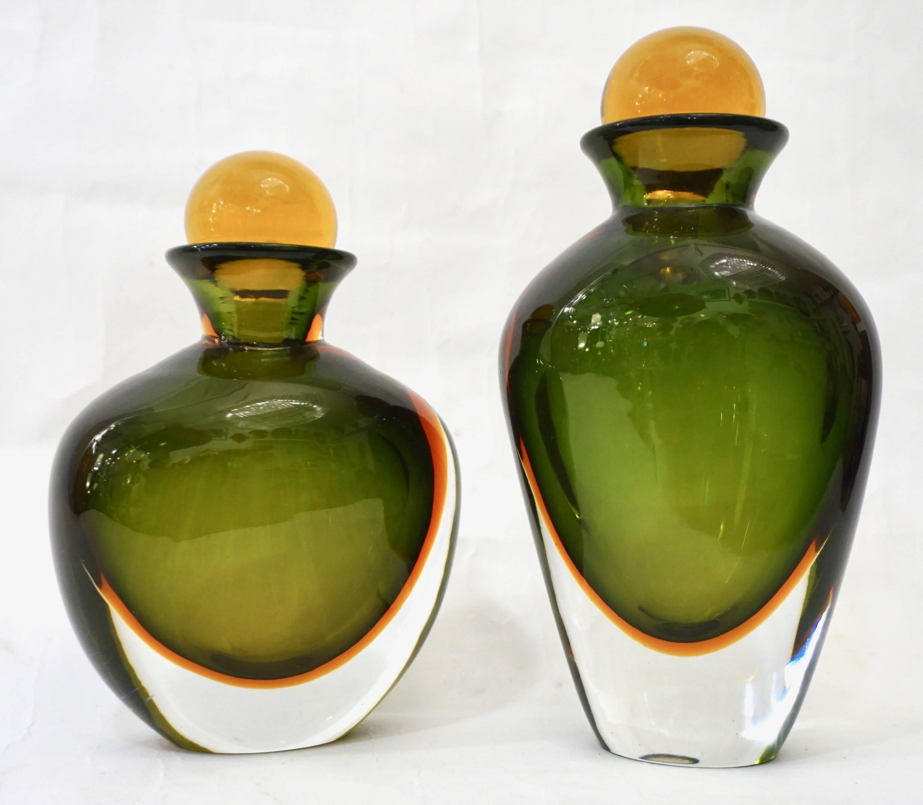 1980s rare Italian set of two ovoid shape bottles with yellow solid stoppers in Murano glass by Formia, beautiful and sophisticated Venetian decoration with the Sommerso technique, the green body encased in the lower part with an orange colored
