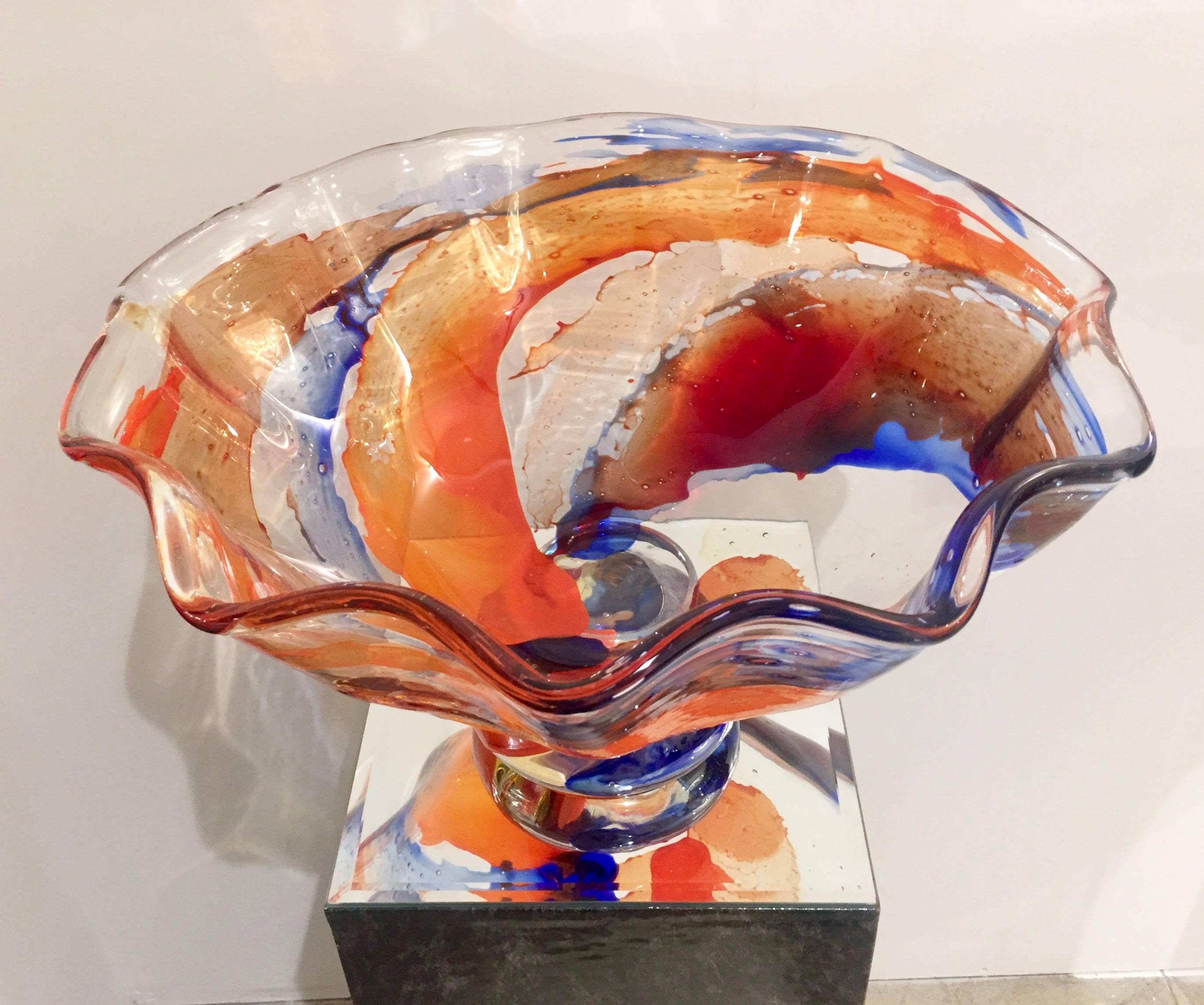 An imposing Studio Art Glass vintage centerpiece in blown Murano glass, the organic body is decorated with strokes of colors like a modern painting that enhance the open waved shape with scalloped edge, raised on a beautiful suggestive round blown