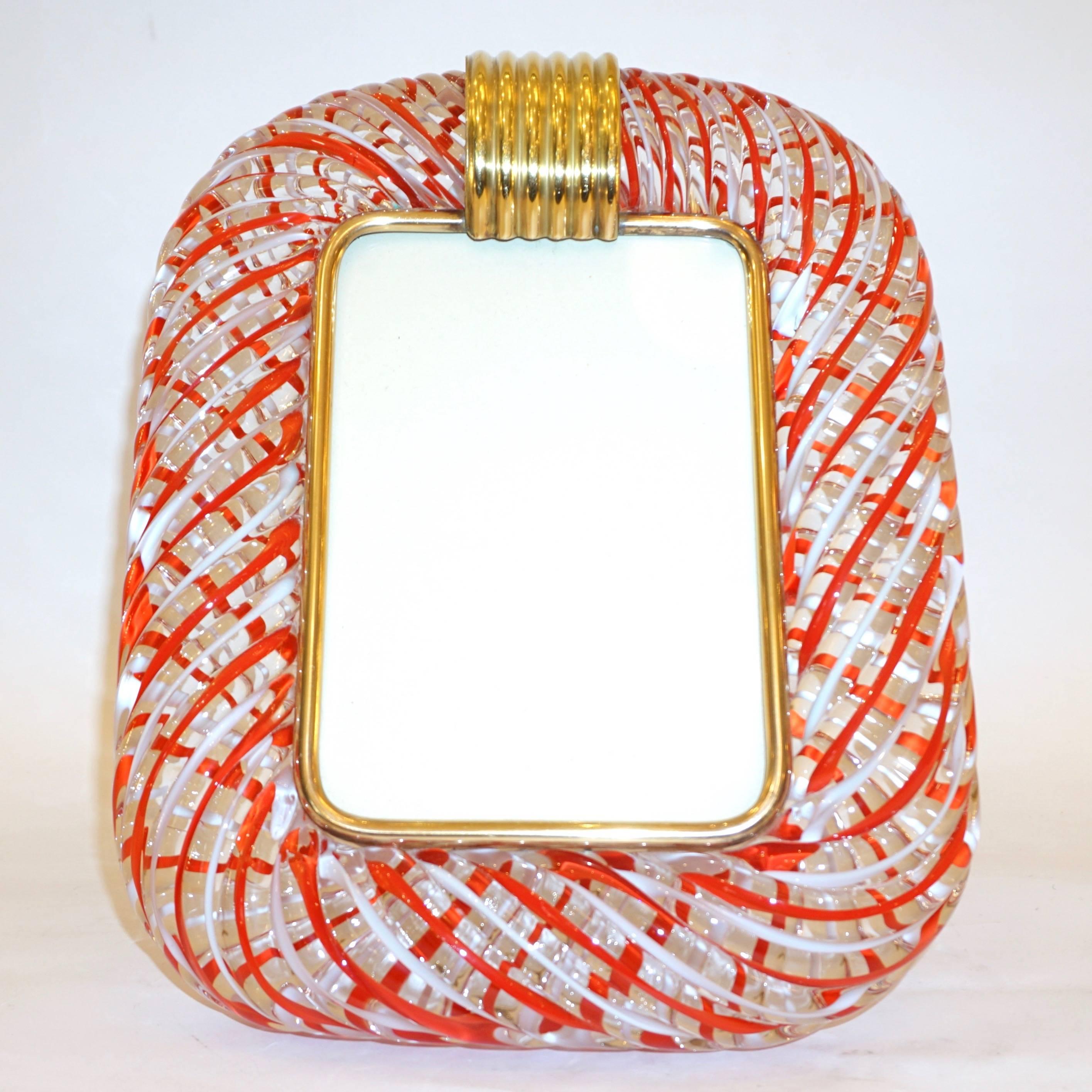 A sophisticated modern design Venetian picture frame in thick blown Murano glass by Venini, signed piece. The decoration of the highest quality, with waved red and white filigrana inside the crystal clear glass, accentuates the texture and the