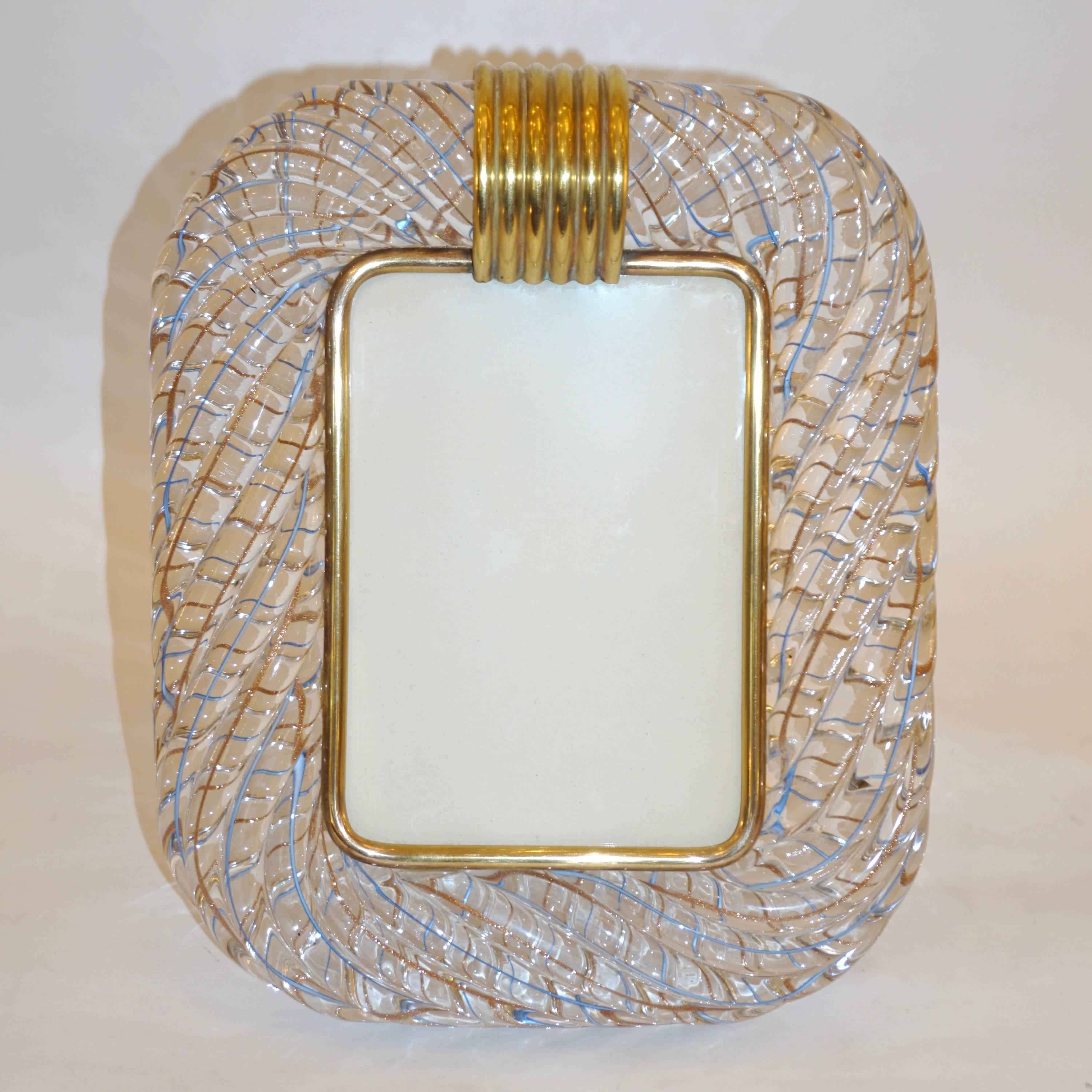Sophisticated and elegant picture frame in thick blown Murano glass signed Venini. The frame worked with “torchon” technique, handcrafted twisted blown Murano glass that amplifies the reflections, accentuated with intertwined copper gold and azure,
