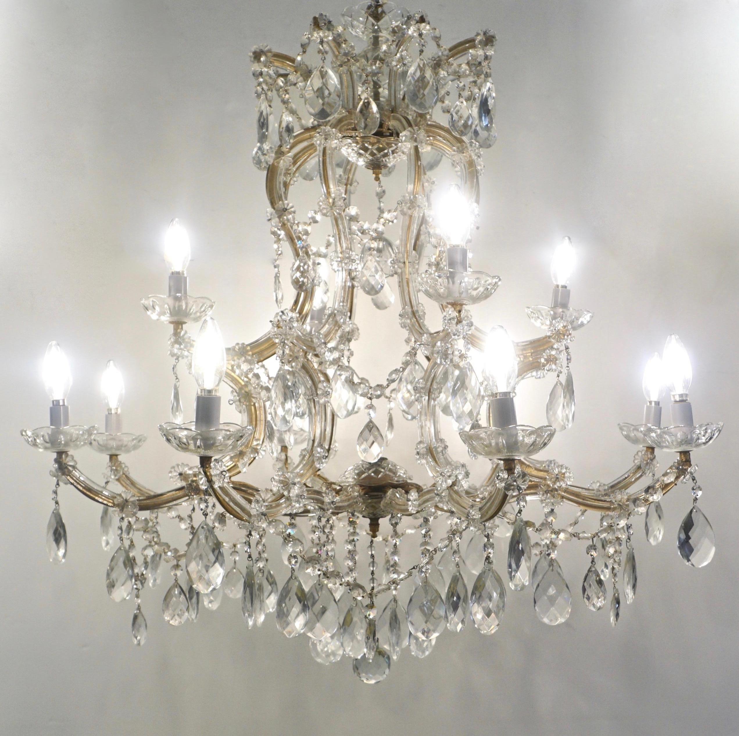 Maria Teresa original chandelier, antique piece entirely handcrafted in Italy late 1930s-early 1940s, with 12 lights, 4 on the upper tier, 8 at the bottom tier, extensively decorated with swags of crystal diamond cut drops and flowers, each arm
