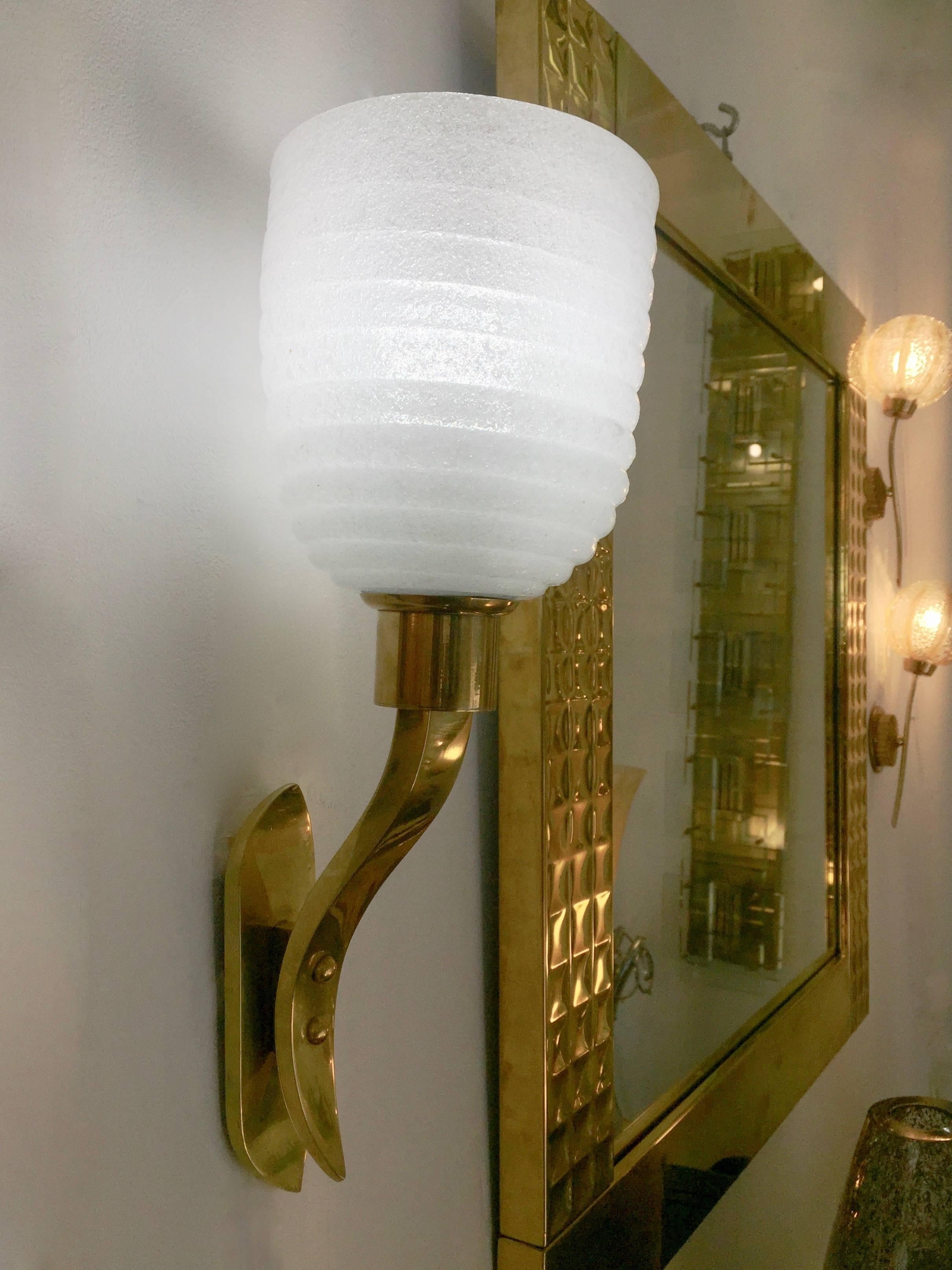 Exquisite pair of mid-century modern Italian high-quality wall lights, entirely handcrafted, the elegantly proportionate bowl shades in white blown Murano glass are decorated with the sophisticated ribbed streamline concentric ring pattern, iconic