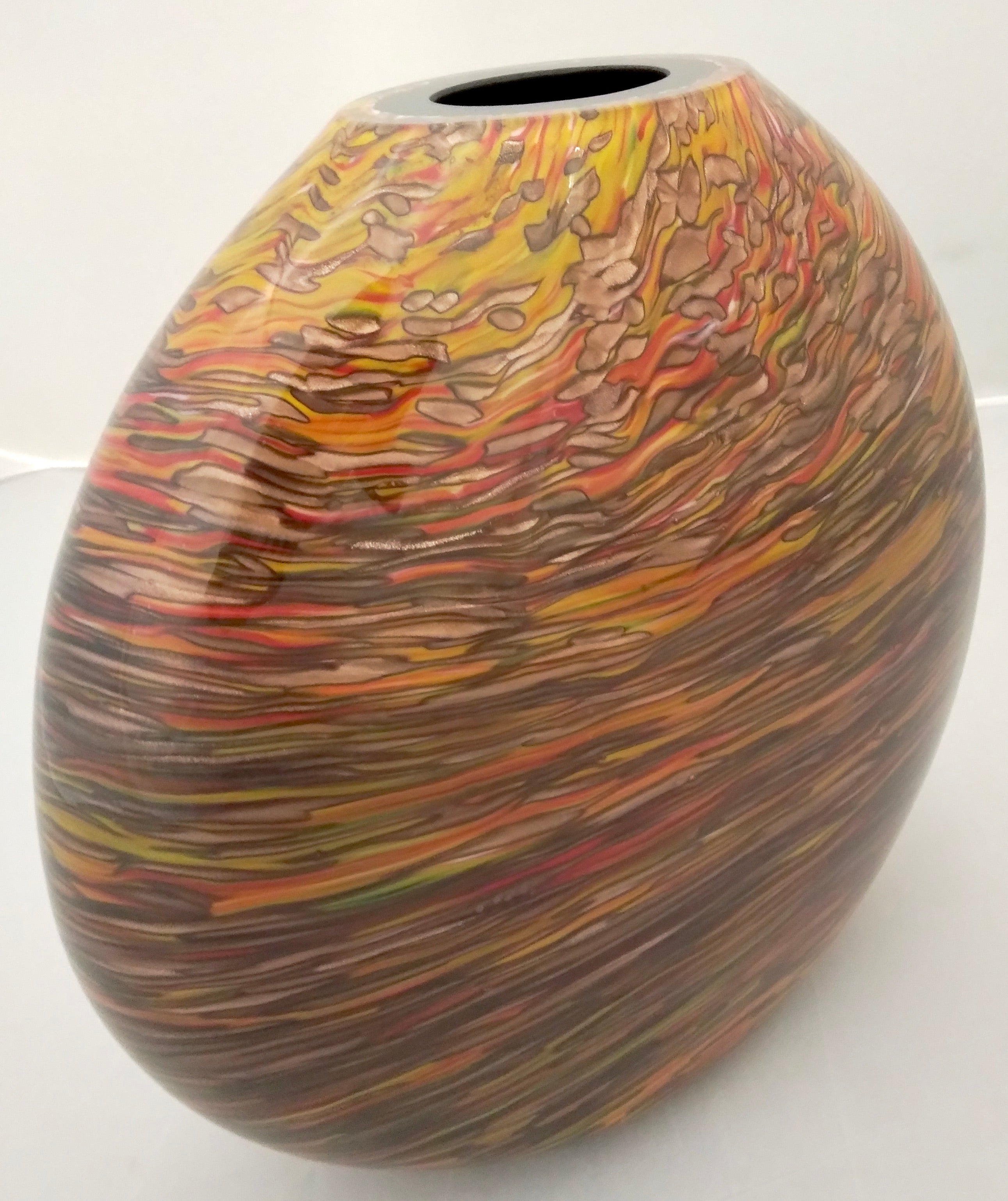 A striking elliptical oval vase, precious Works of Art in blown solid black Murano glass worked like a modern painting with a sophisticated extensive organic firey decor of overlaid elongated murrine in brown, green, yellow, orange, red colors
