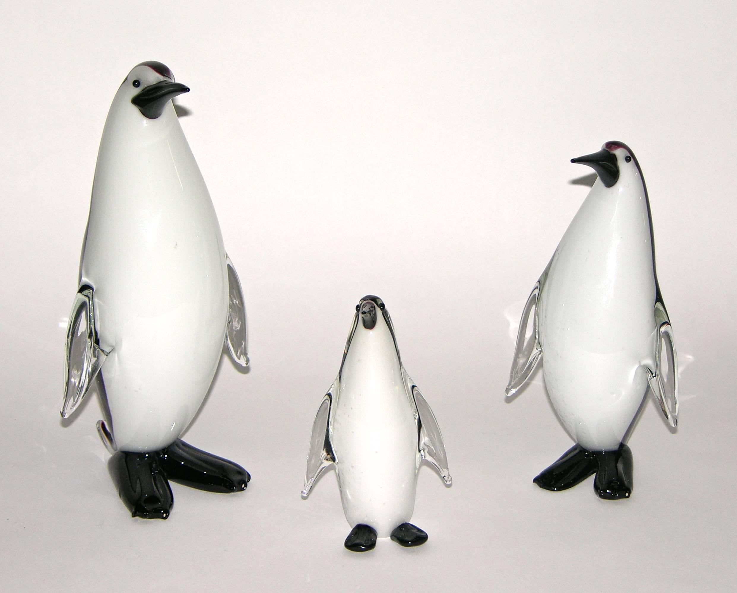 Three penguins of different sizes forming a group, in blown overlaid black and white Murano glass, the black color with graduated purple edges, to add relief. Bearing Formia Murano labels.
Dimensions of medium penguin: H 8.25 in W 4.25in D 3.5