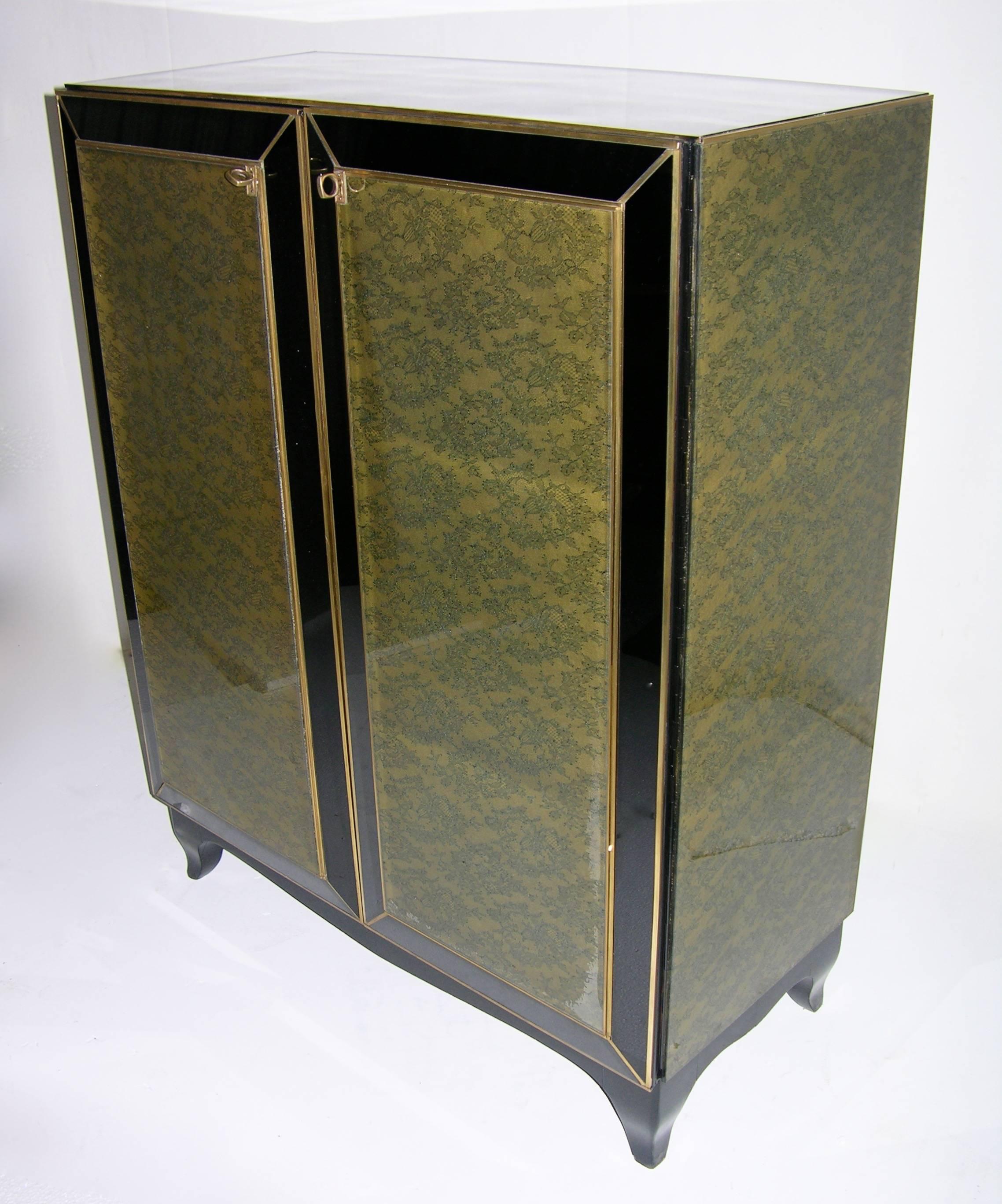 An Italian custom-made credenza/buffet, very rare decor with sides and front decorated with olive green lace over an elegant musk green fabric under glass panels, the surround in black glass highlighted with bronze inlays, on scrolled black