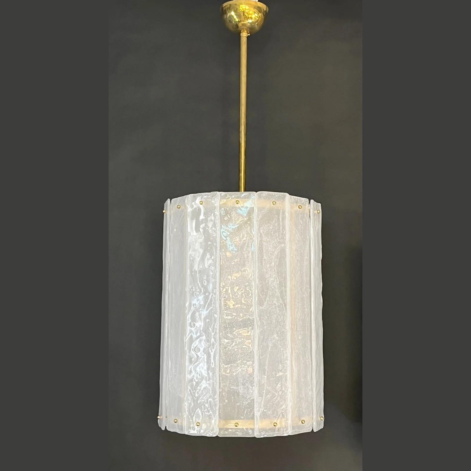 Unique contemporary Italian Art Deco design round pendant chandelier, entirely handcrafted. This light fixture is composed of a handmade brass structure supporting overlapping Murano glass bands, the frosted crystal  worked with bubbles in the glass