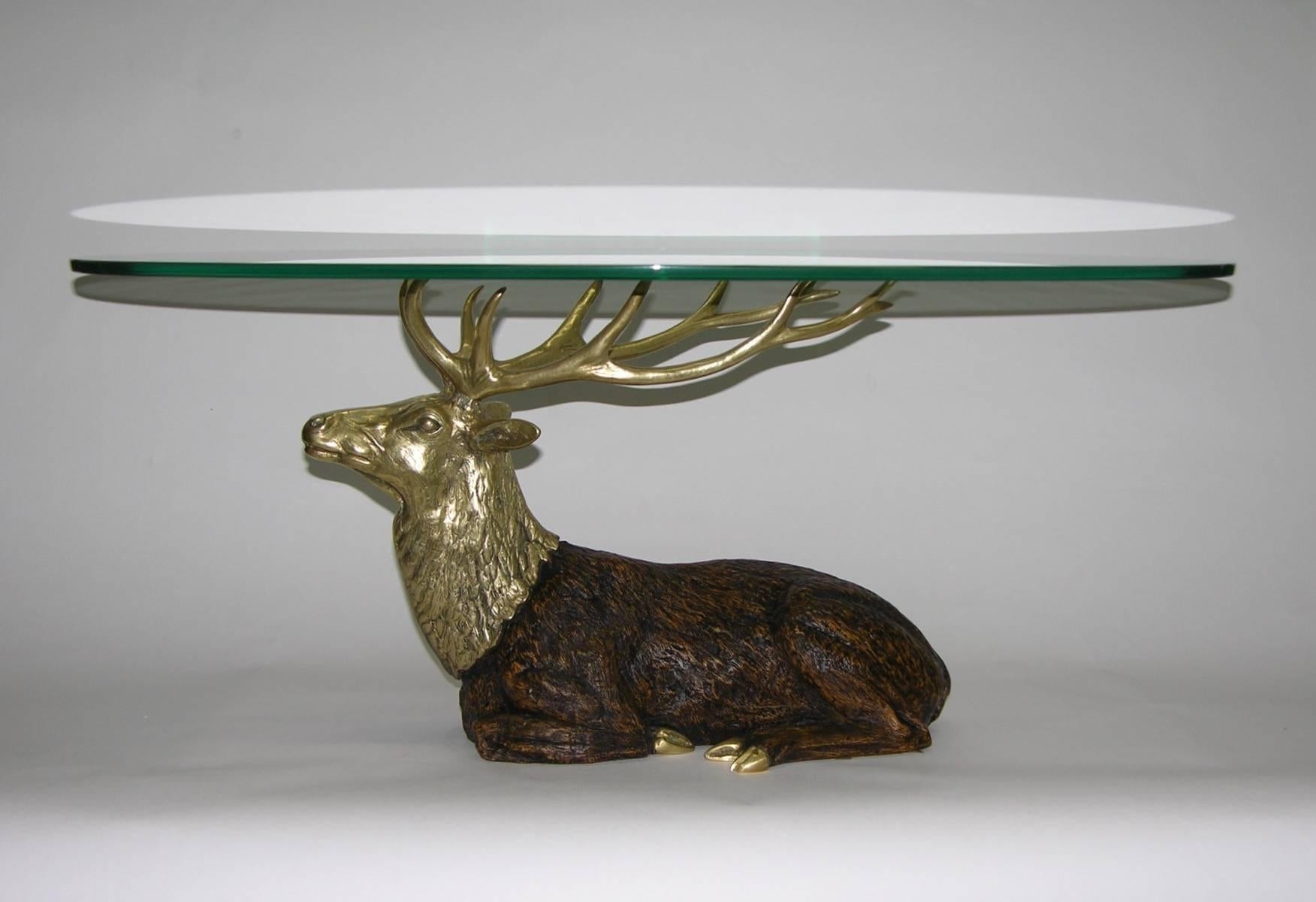 A striking and very interesting coffee table, the oval glass surface rests on bronze antlers of a high quality sculpted and hand-carved walnut deer with hooves and head in cast bronze, with refined details. Ideal for chalet-style. 