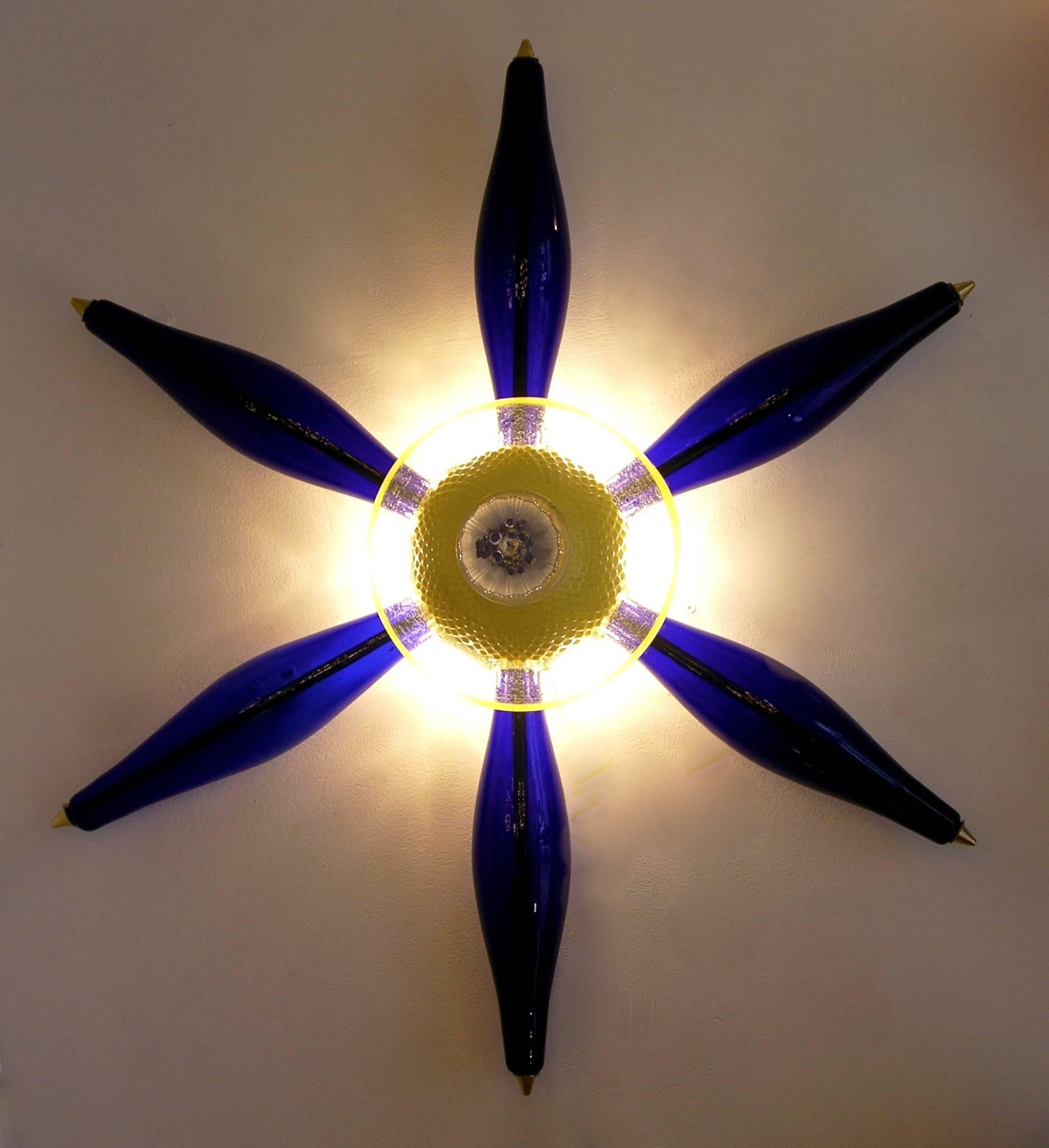 One-of-a-kind Italian design unusual wall lights, in the shape of a flower or six-point star. Six very rare blown blue Murano glass elements, jutting out of a precious core consisting of yellow and clear Murano glass components executed through