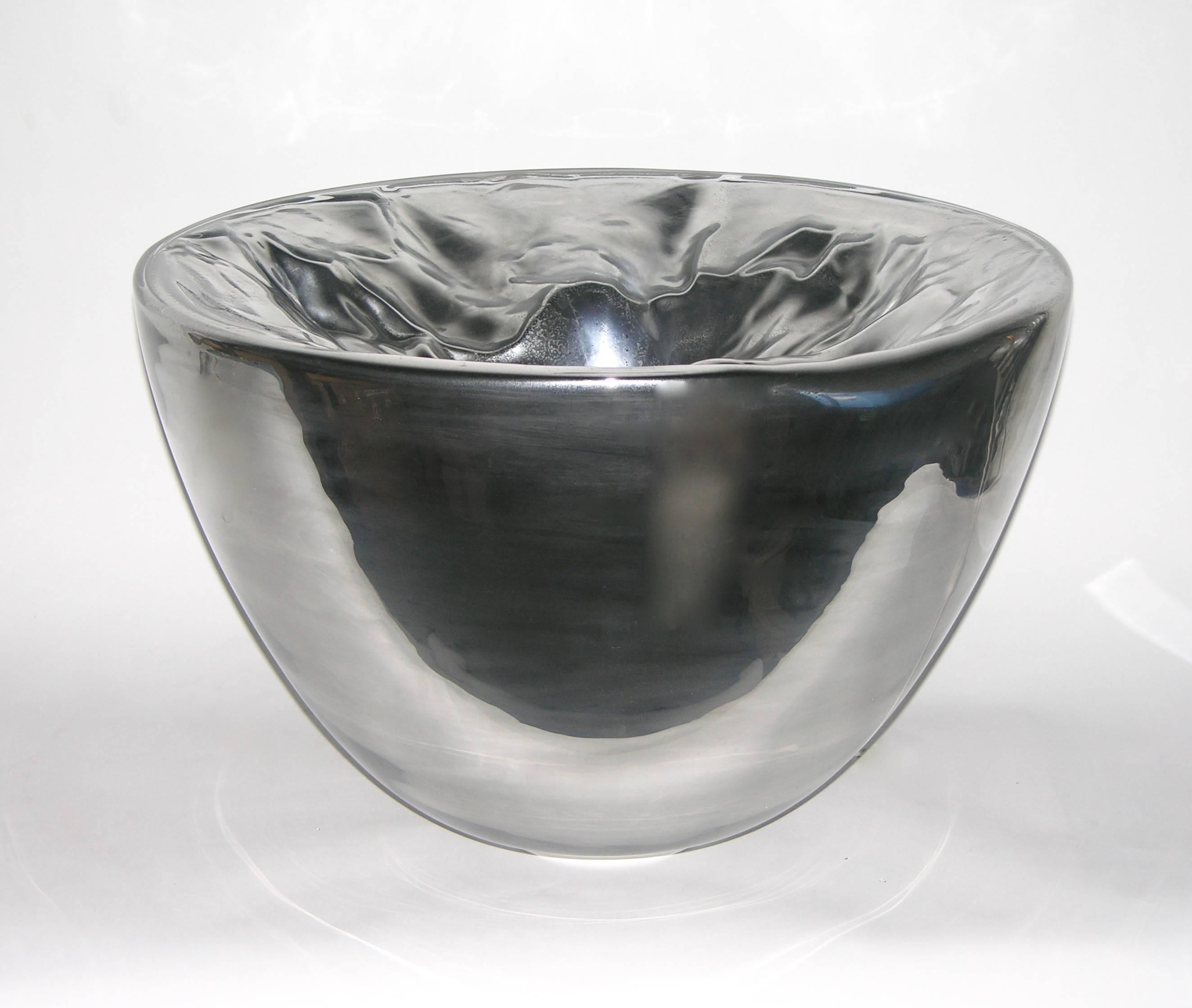 These monumental illuminated bowls by Carlo Nason in blown Murano glass, rarer in this silver version are decorated with a rock appearance, the glass roughly ridged and corrugated. They can be displayed also on the floor and their monumental size