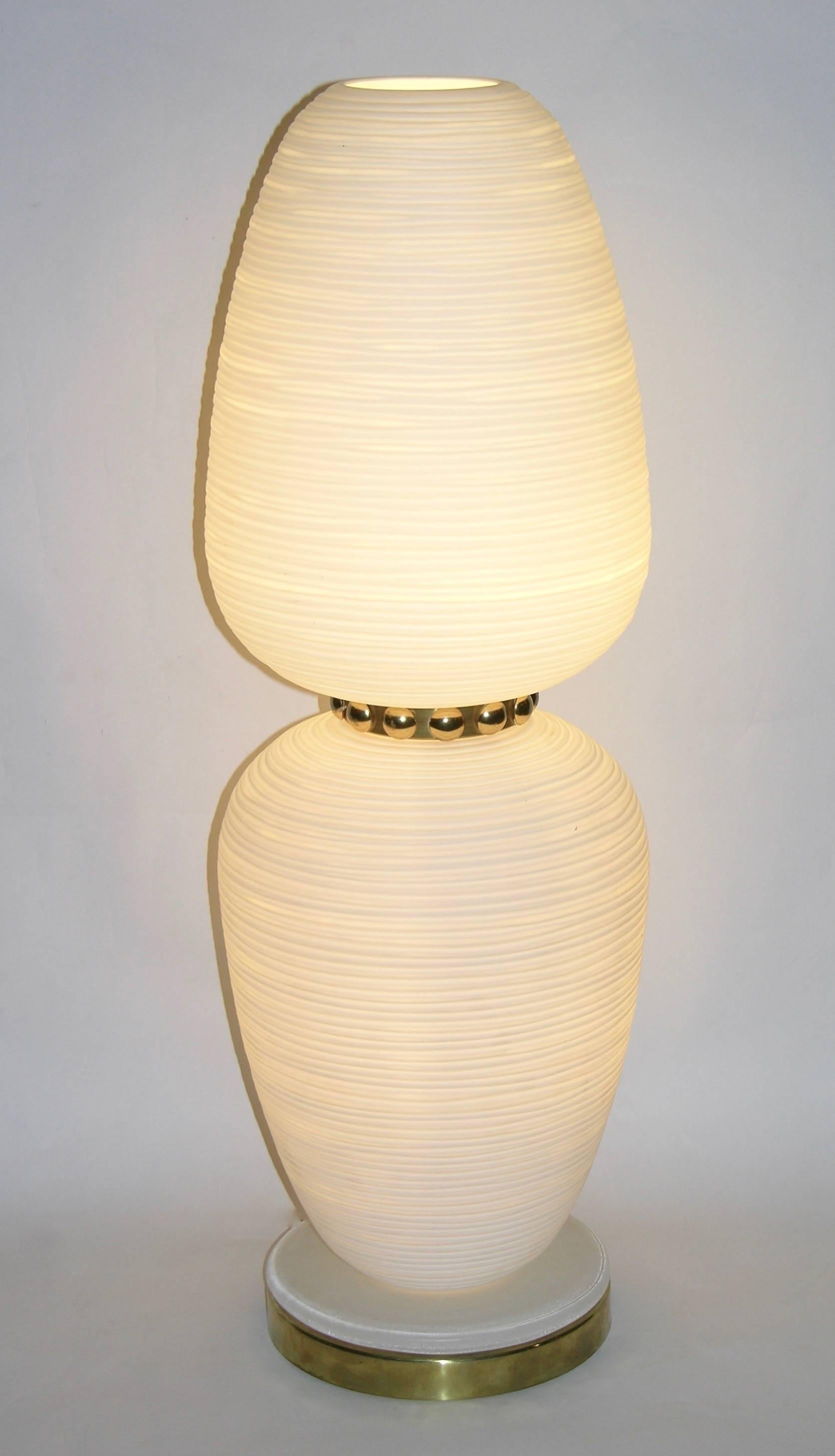 A rare pair of high quality Italian lamps by Vistosi in white blown Murano glass, worked with a very rare and difficult technique that gives a ceramic appearance and an incredible texture of fabric to the glass. The two ovoidal bodies, each with