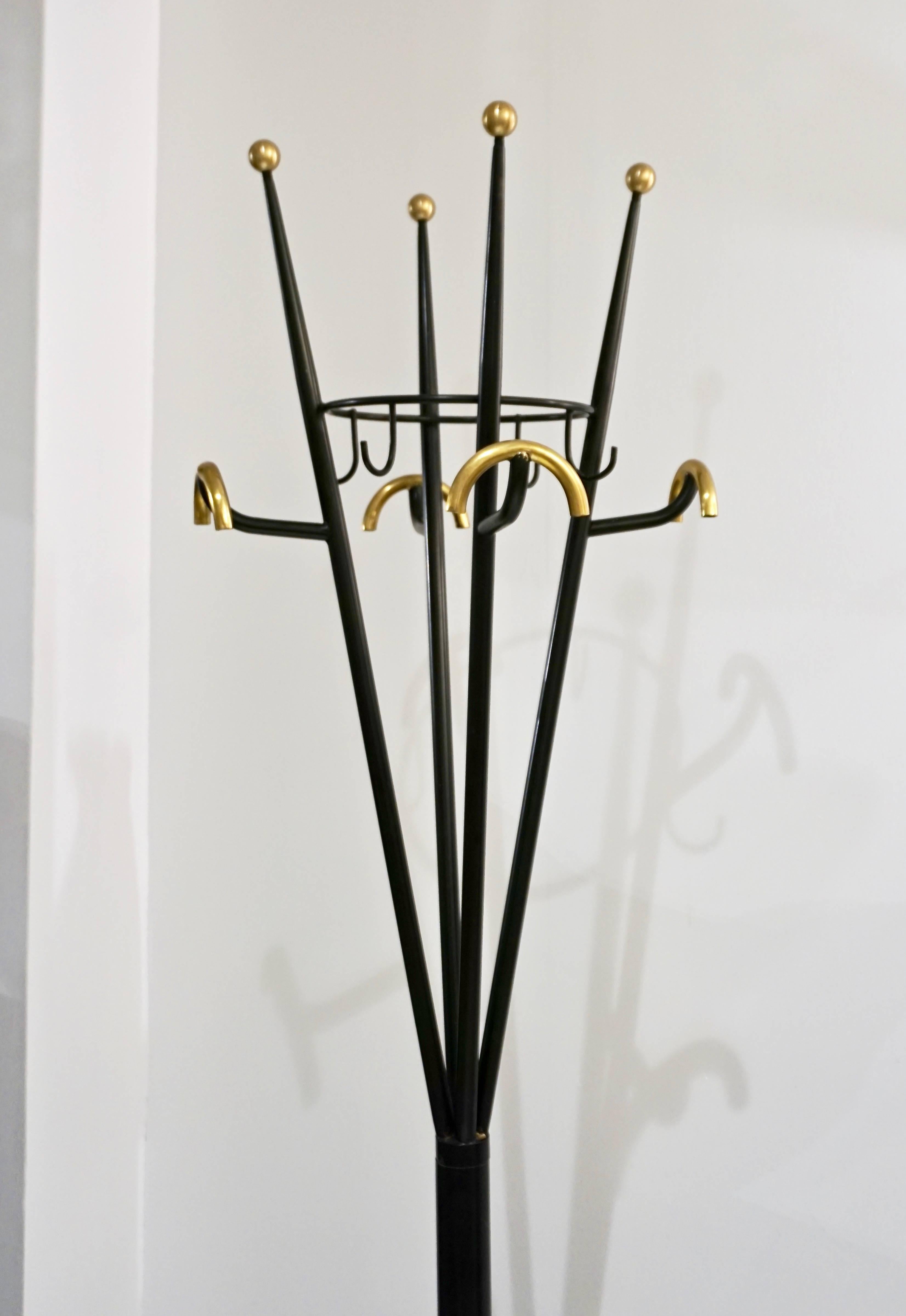 Very practical and highly decorative 1980s Italian coatrack/hat hanger and umbrella stand with one-of-a-kind streamlined design. Entirely handcrafted in black lacquered metal highlighted with brass details, it features four umbrella holders with a