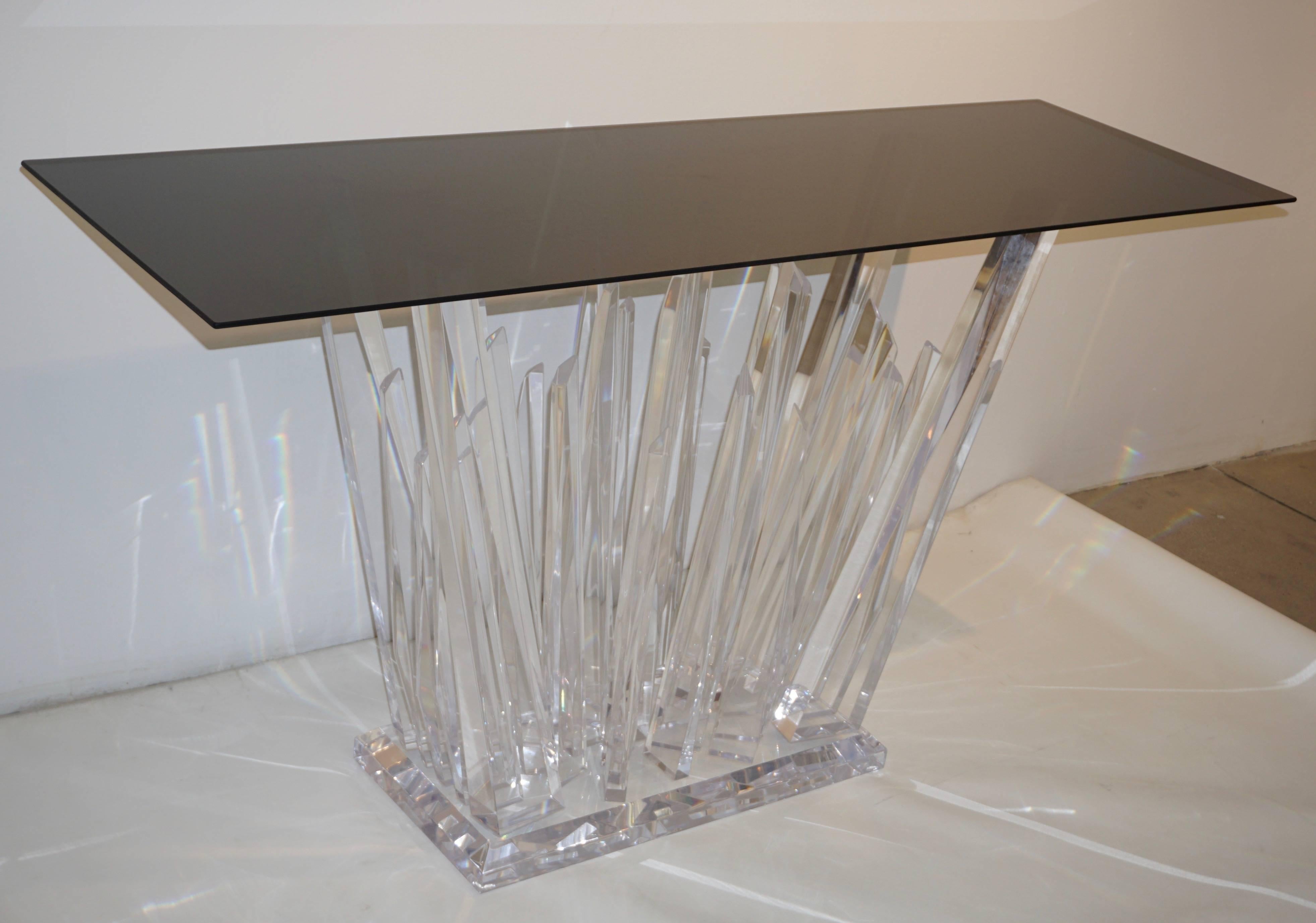 A very attractive and fun contemporary acrylic central console table in high quality clear plexiglass that looks like rock glass, the exclusive modern abstract decor raised on a deep bevelled plinth gives movement and texture to this sculpture piece
