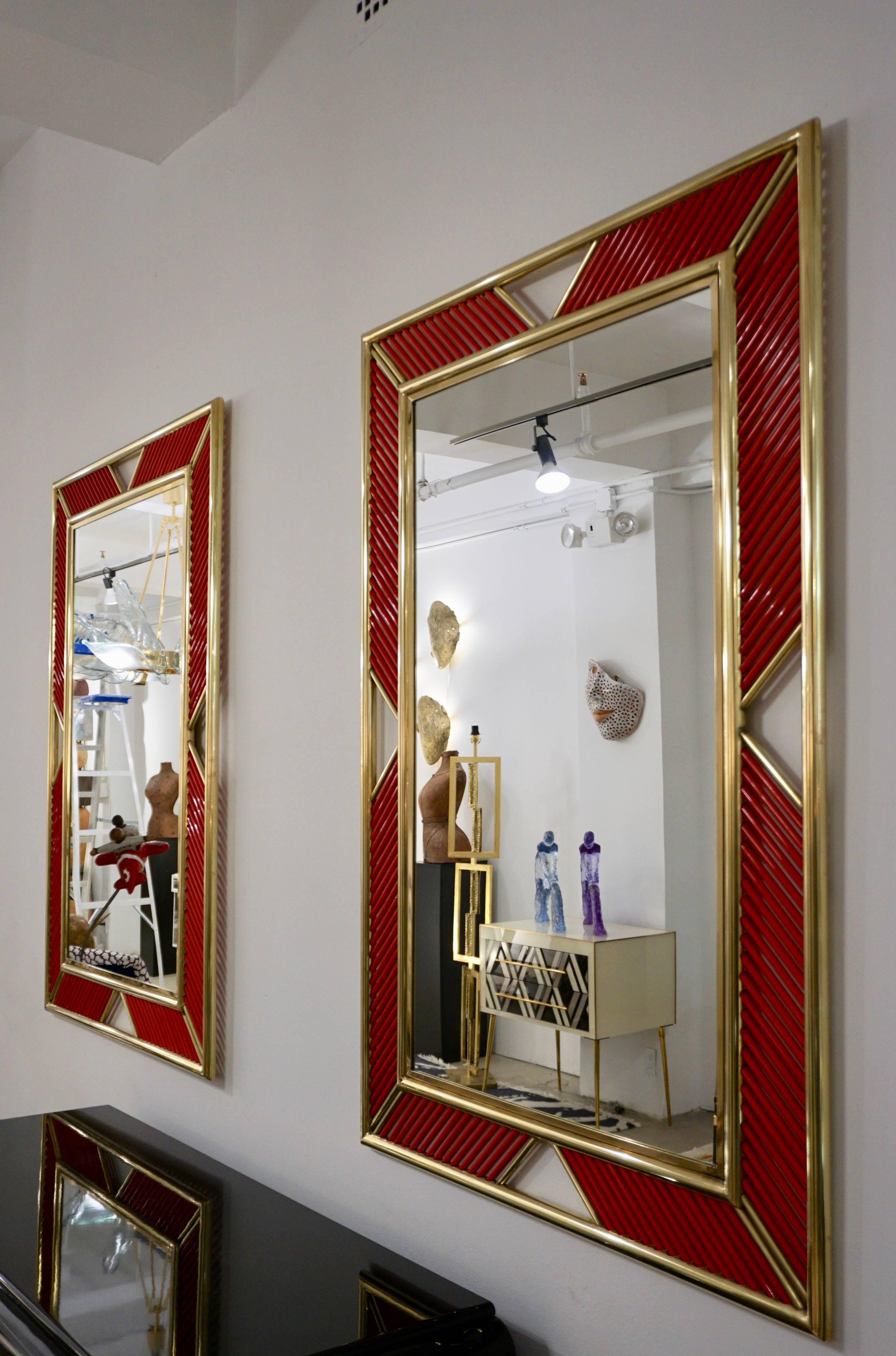 Italian airy mirror with a contemporary modern handcrafted double brass frame adorned with exquisite Murano glass baguettes in a beautiful red color which can be customized. The craftsmanship is of high quality with attention to details like the