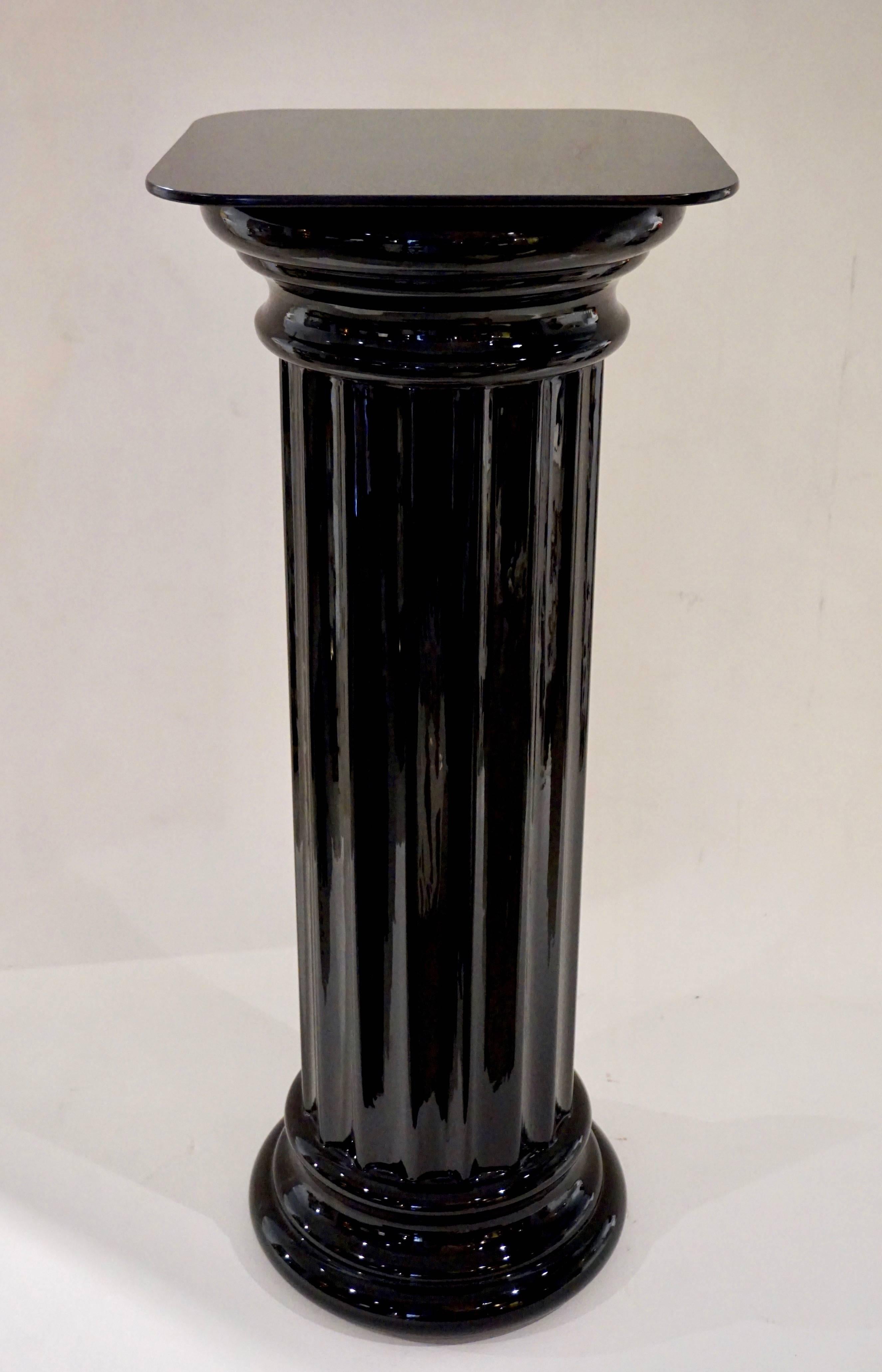 Pair of Italian pedestals with fluted bodies in high quality shiny black blown glass, with shaped moulded plinth and top, finishing with a square top surface to provide maximum exhibit space, a rare item being in glass with a perfect height for a