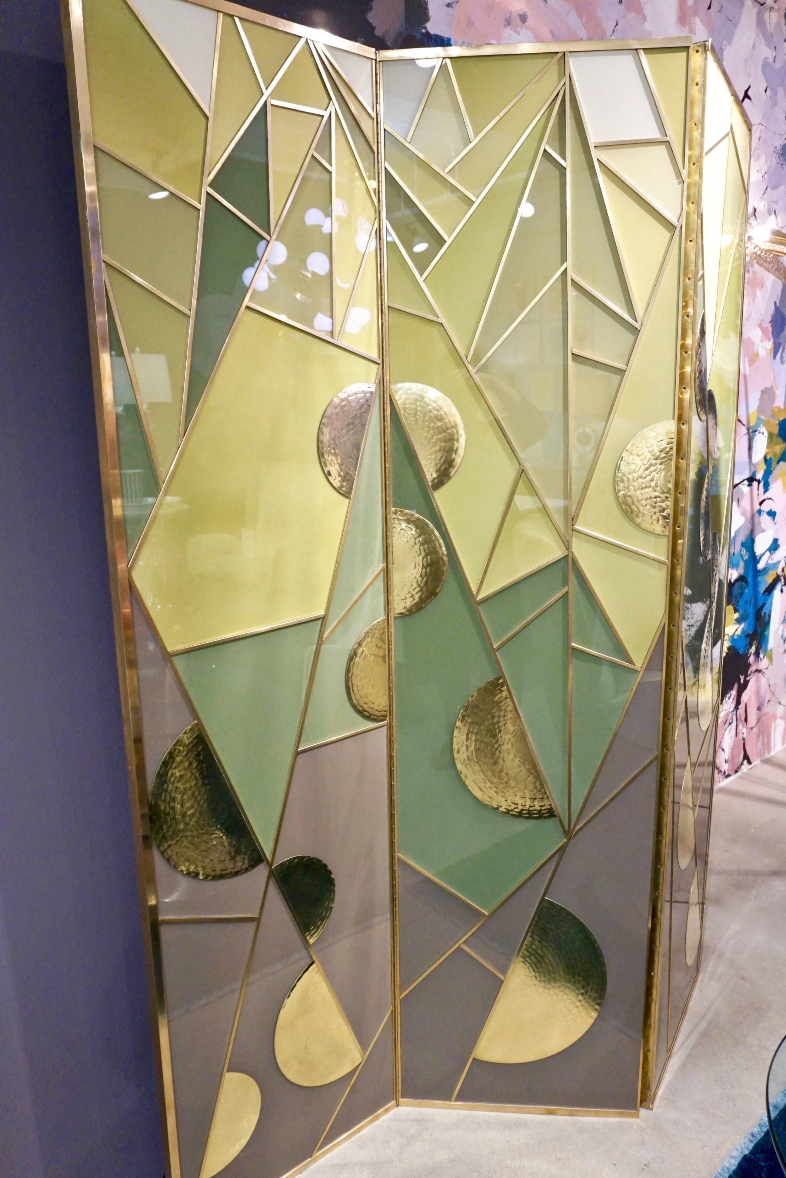 Modern one-of-a-kind Art Deco design brass framed three-panel room divider from the 1980s, entirely handcrafted, made in Italy. Each panel is decorated like an Art sculpture with an abstract brass edged geometric pattern in glass with different