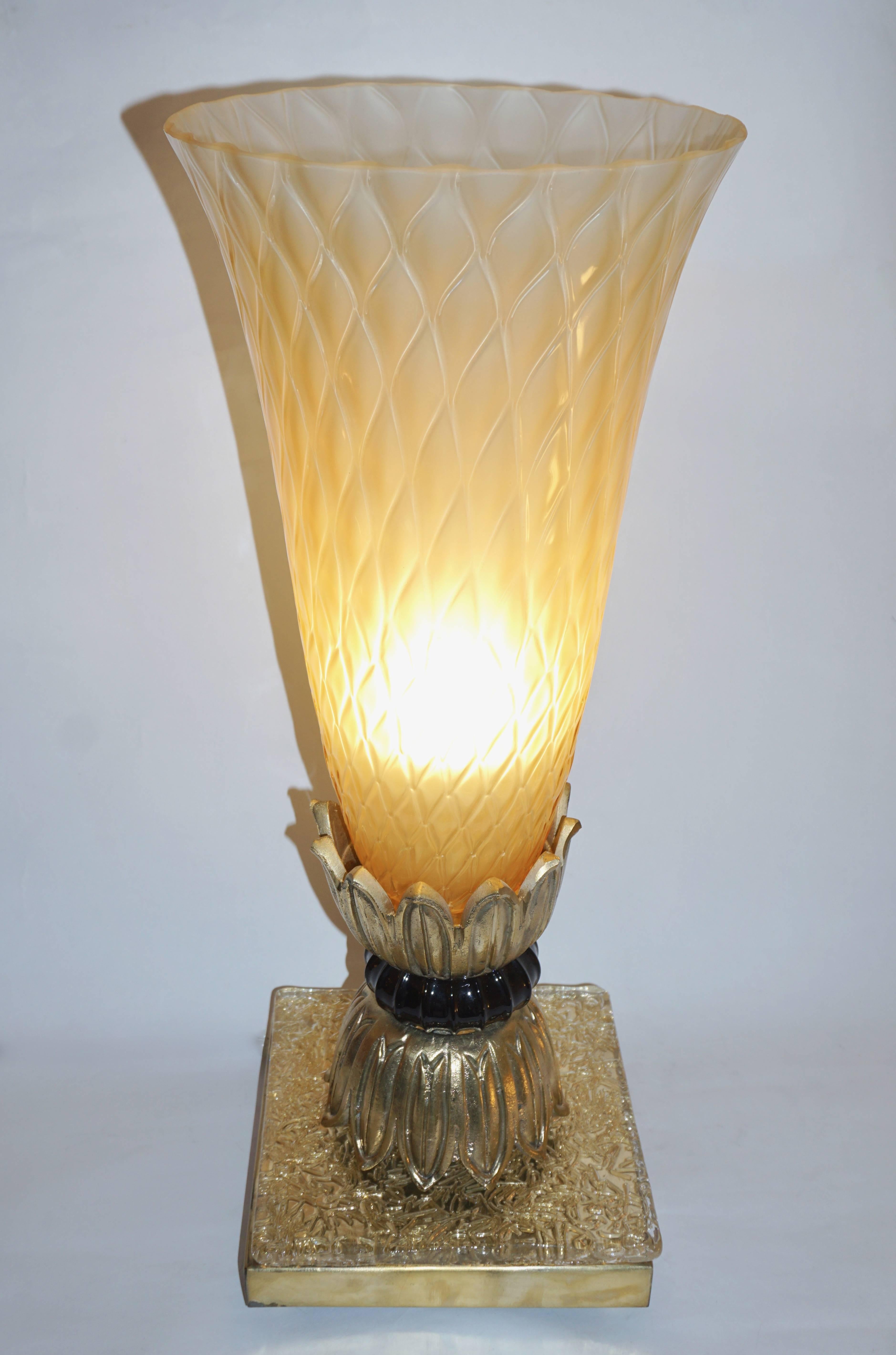 Venetian elegant pair of Art Deco design lamps attributed to Barovier Toso, circa 1970, with exquisite blown glass shades in textured honeycomb amber gold Murano glass supported by cast bronze decorative corollas, raised on a handcrafted brass base