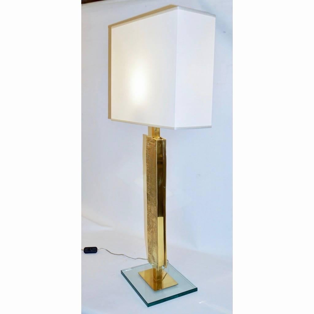 Italian linear sculpture geometric table lamps, entirely handcrafted with a very interesting modern custom design, constructed as a Minimalist stele, the upright brass column decorated with markings in relief, raised on a brass rectangular support