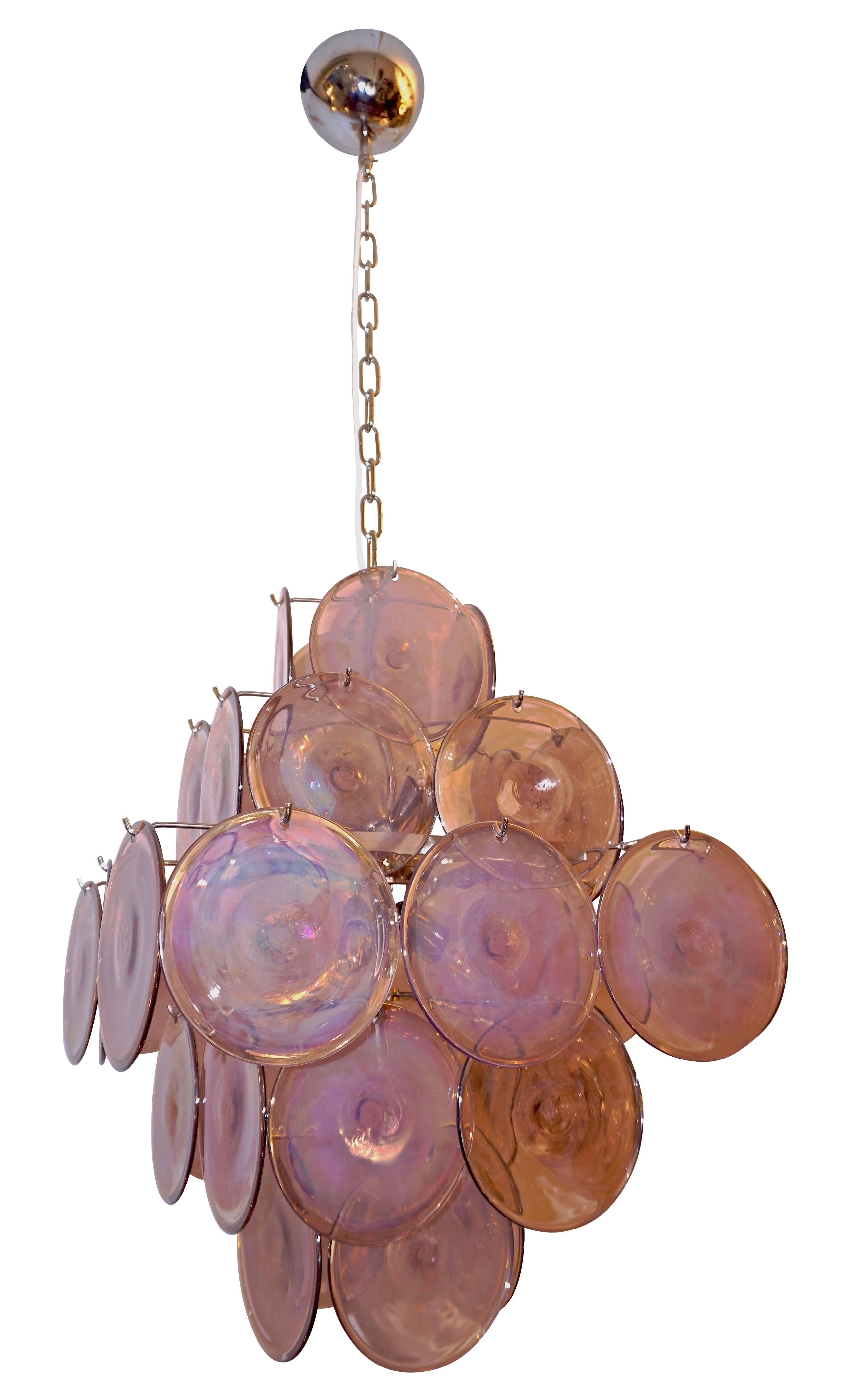 A fun vintage Italian Art Deco design chandelier pendant by Vistosi, entirely handcrafted, composed of a five tiered nickel structure supporting 36 blown Murano glass disks in a delicate pink color worked with a precious iridescence that makes the