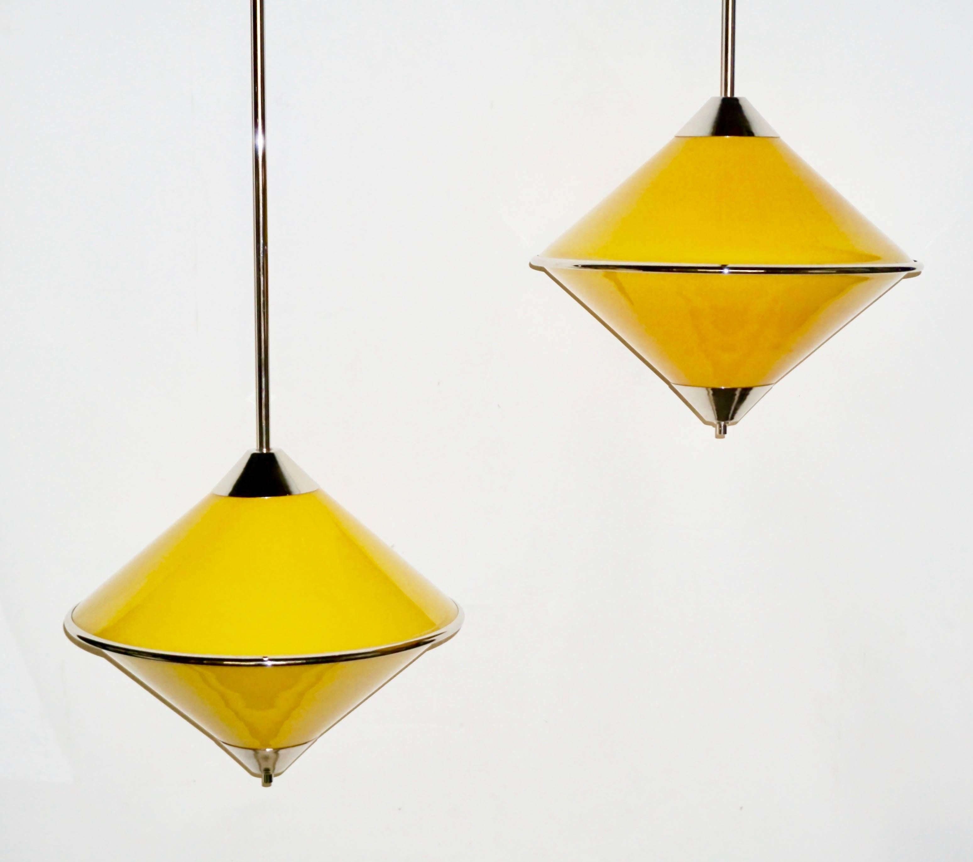 A vintage Italian pair of joyful pendant lamps by Fratelli Toso, entirely handcrafted, in high quality blown Murano glass of interesting enamel yellow color overlaid in white to produce plenty of light when lit. The rhombus shape is highlighted by a