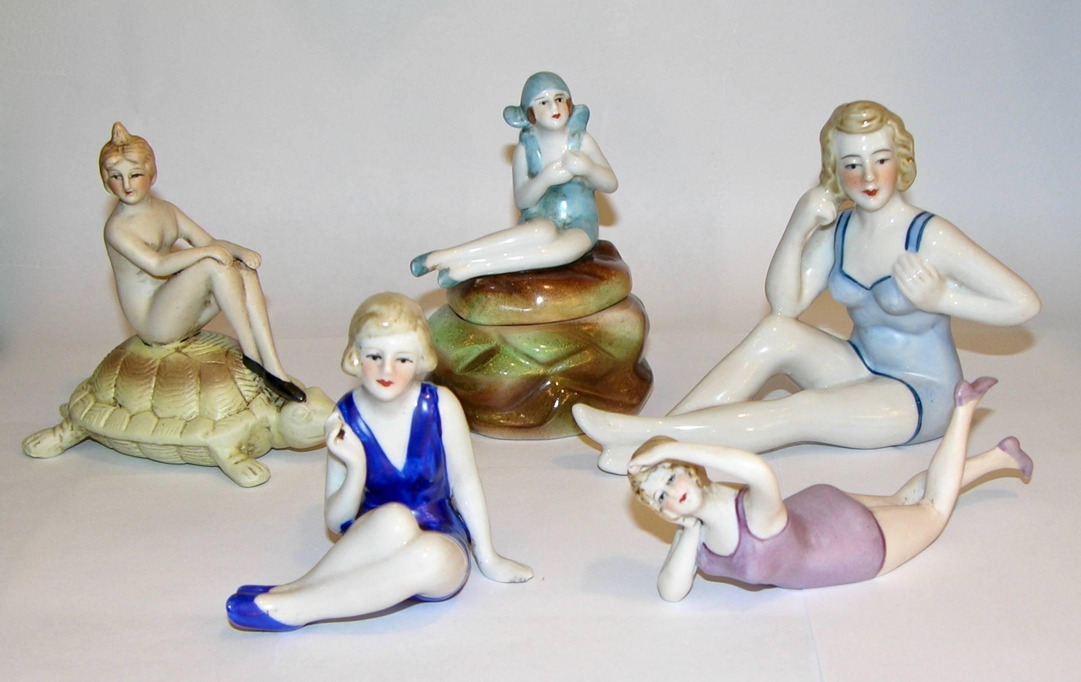 A delightful group of Art Deco ceramic female figure sculptures, each nicely detailed and hand-painted, representing bathing beauties in white and red, black, blue, light blue, yellow, pink bathing suits, in various poses, one seated on a tortoise,
