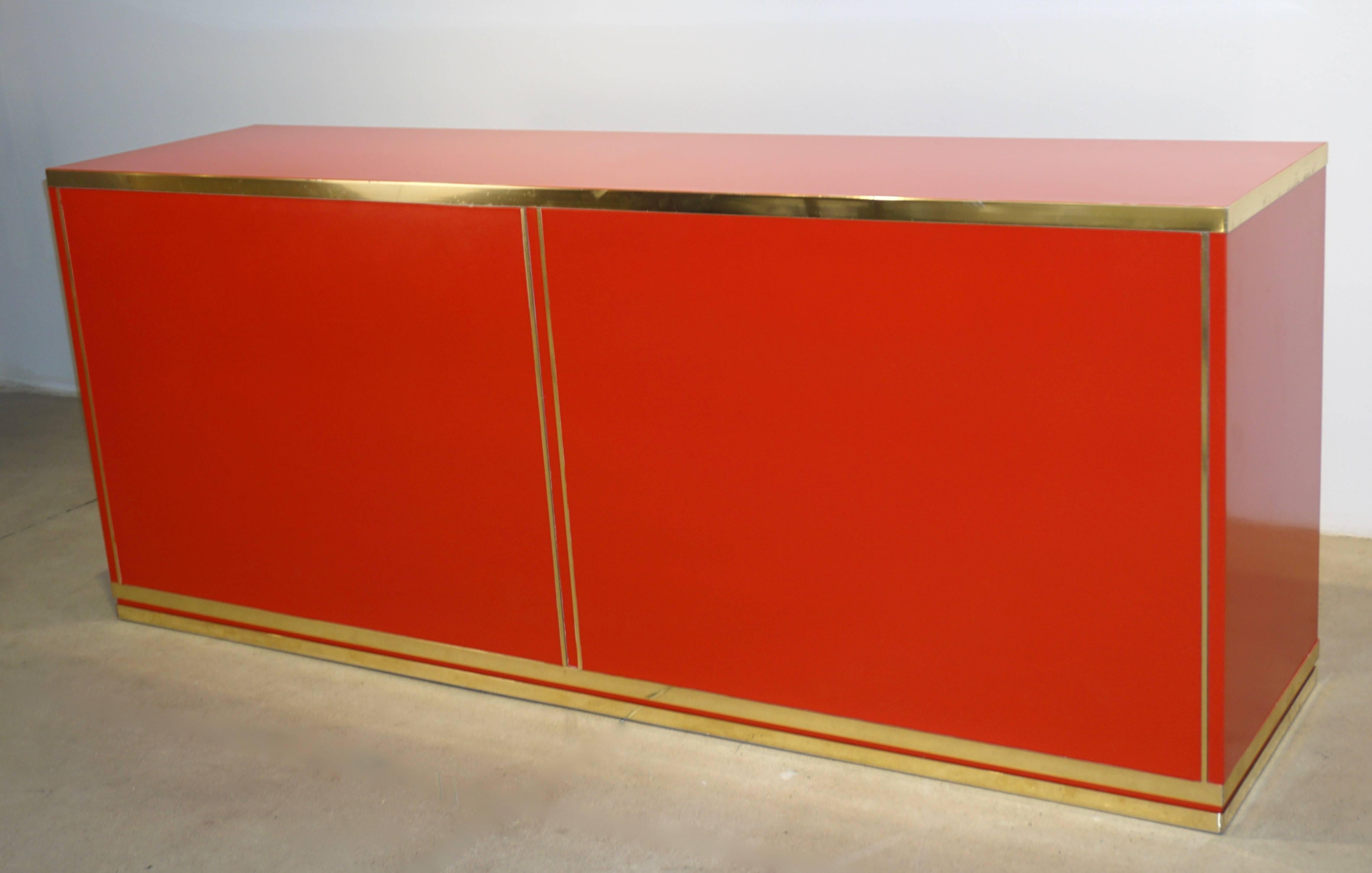 One-of-a-kind Italian vintage sideboard or cabinet by the Roman Company l'Angolo Metallarte, entirely handmade, China red lacquered wood surround with Minimalist decor of oriental inspiration highlighted by flat brass circles and edged on the four