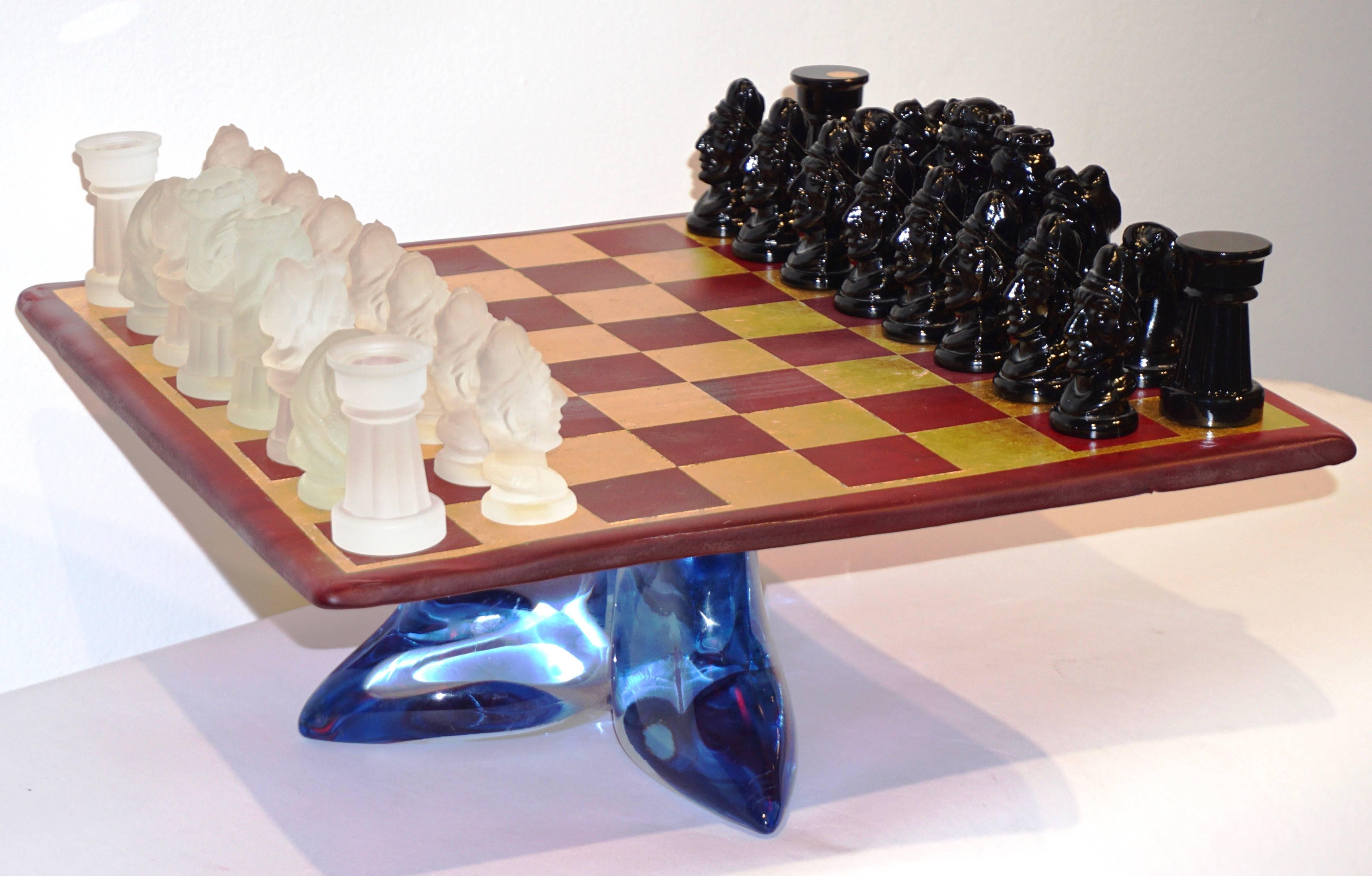 A very rare vintage Italian chess game of modern design by Ermanno Nason for Cesare Toso, the detailed chess pieces are molded in white frosted and black Murano Art glass, the blown glass board is in translucent red hand decorated with squares in