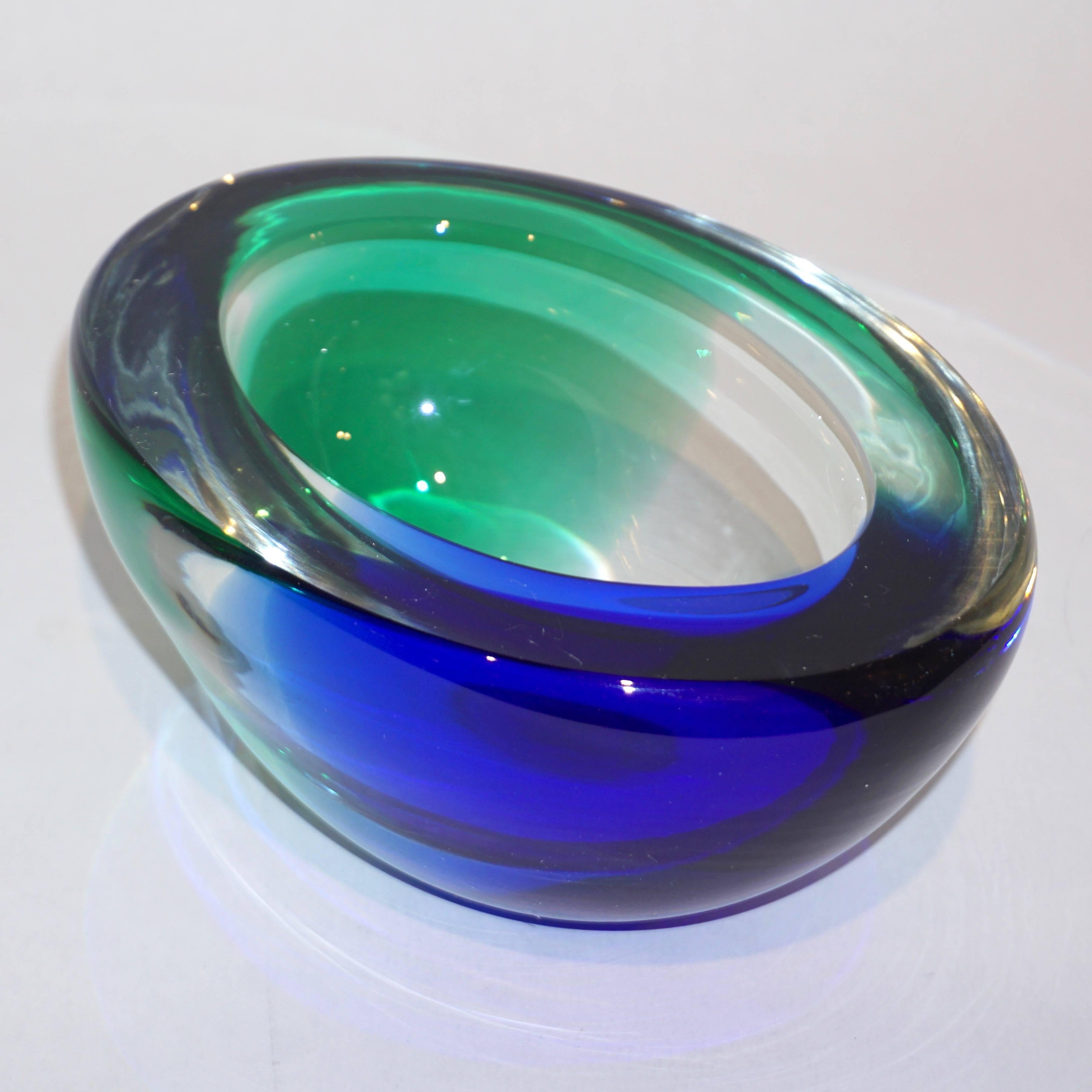 Vintage organic modern 1970s blown Murano glass bowl or catchall dish in emerald green and cobalt blue, signed by Venini, elegantly decorated in patch colors that catch the light and enhanced the shape with flat cut polished top. Also, available in