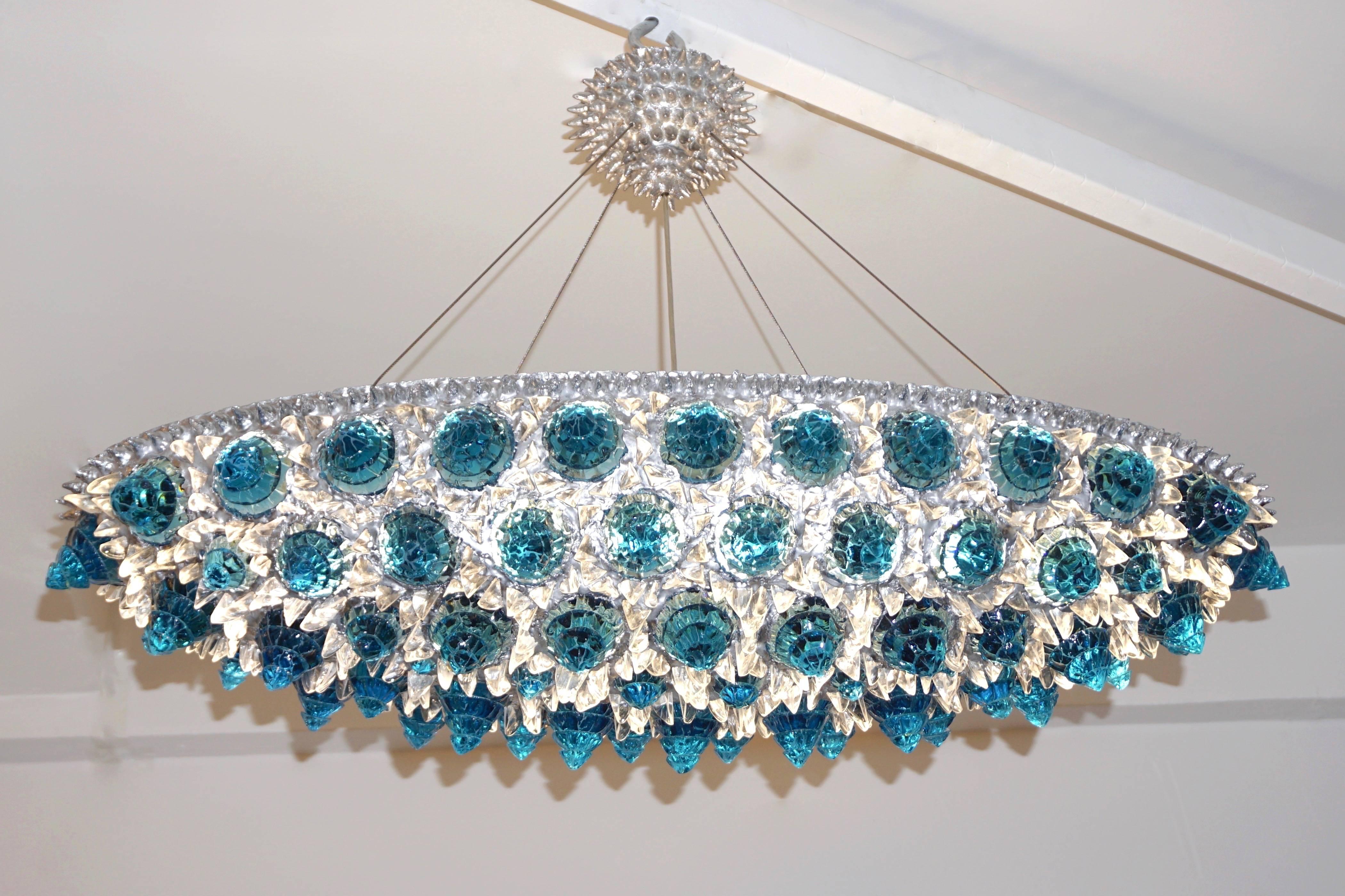A jewel like Italian oval pendant or flush mount chandelier, Work of Art sculpture, entirely handcrafted, the sophisticated organic decoration is composed of hand-cut rock glass diamond elements of different sizes set in a hand-cast iron frame