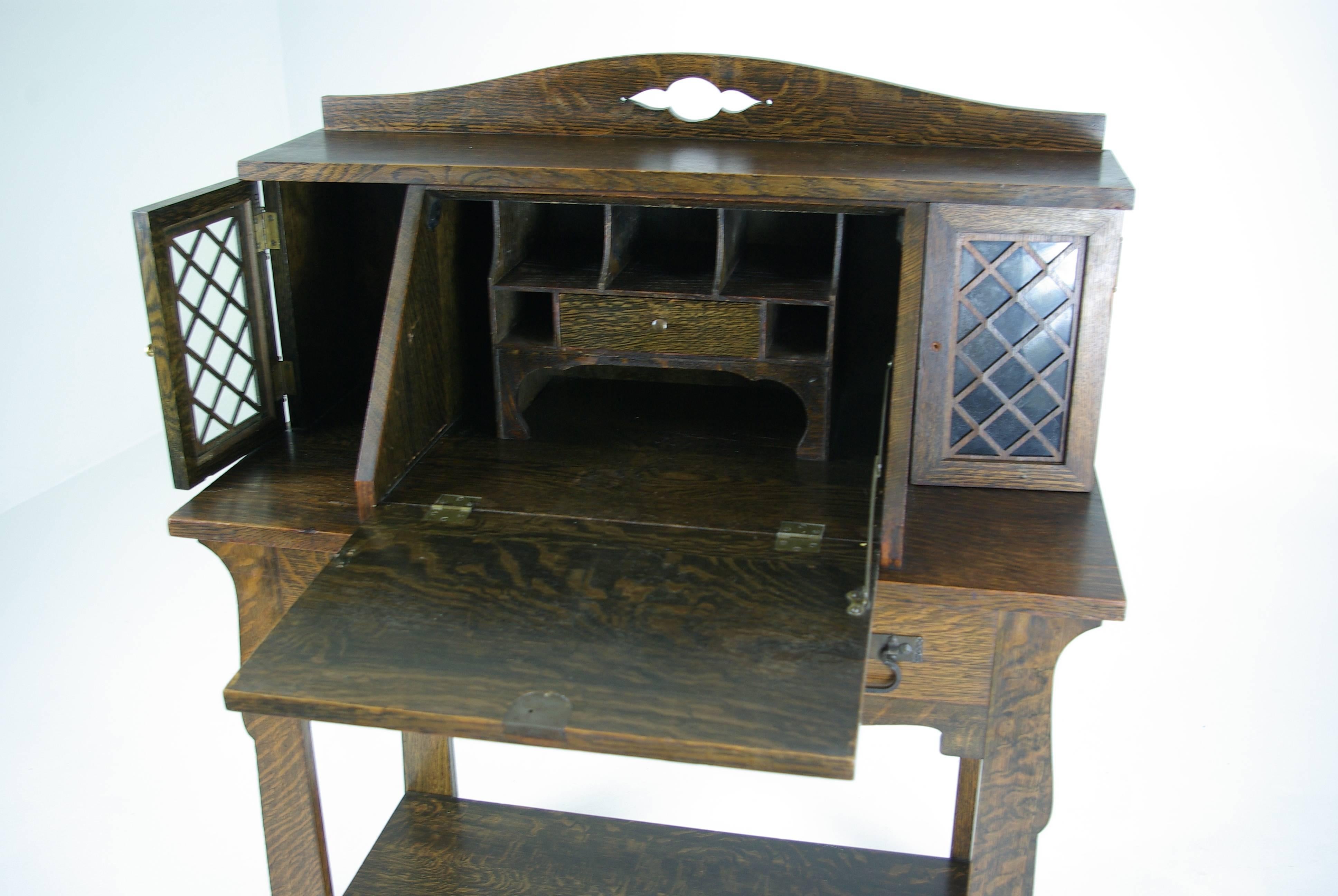 All original finish.
Tiger oak.
Slope front fitted interior.
Flanked by two small cupboards.
Single drawer below.
Original hardware.
Sitting on shaped legs.
Open back with shelf below.
Wonderful color and condition.
Note one handle is